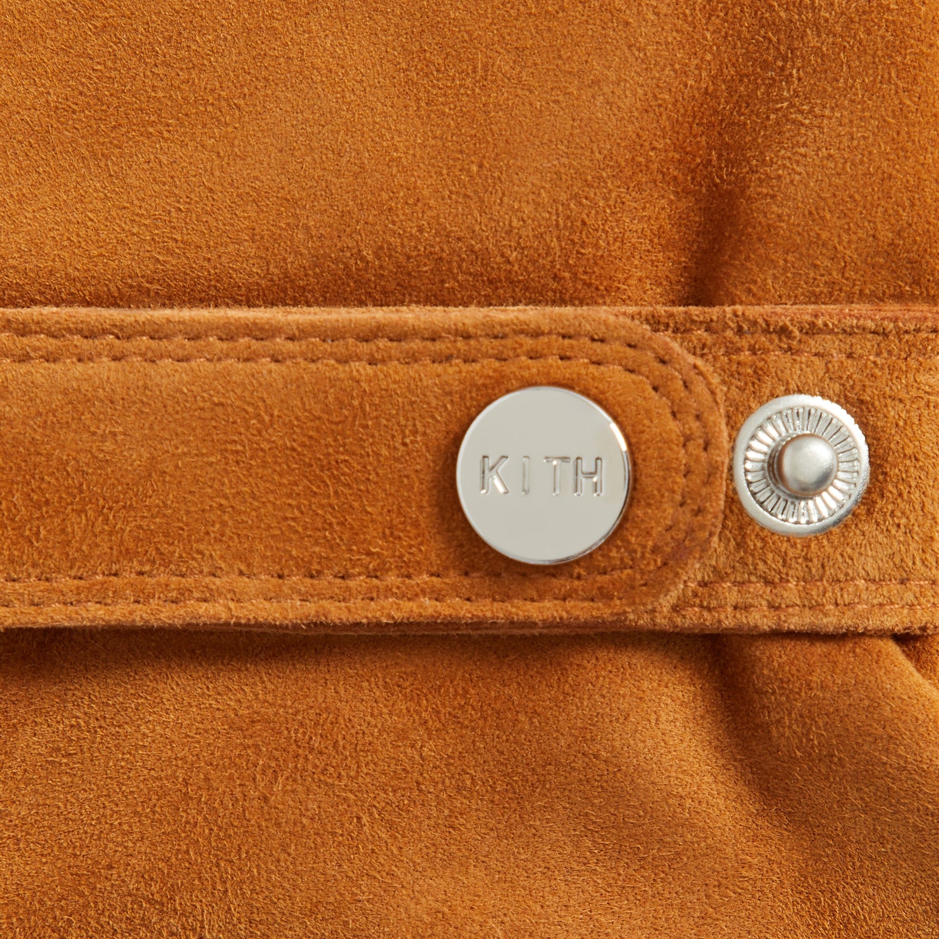 Kith Suede Manhattan Gloves in Argil, close-up of wrist strap snap button engraved with KITH logo