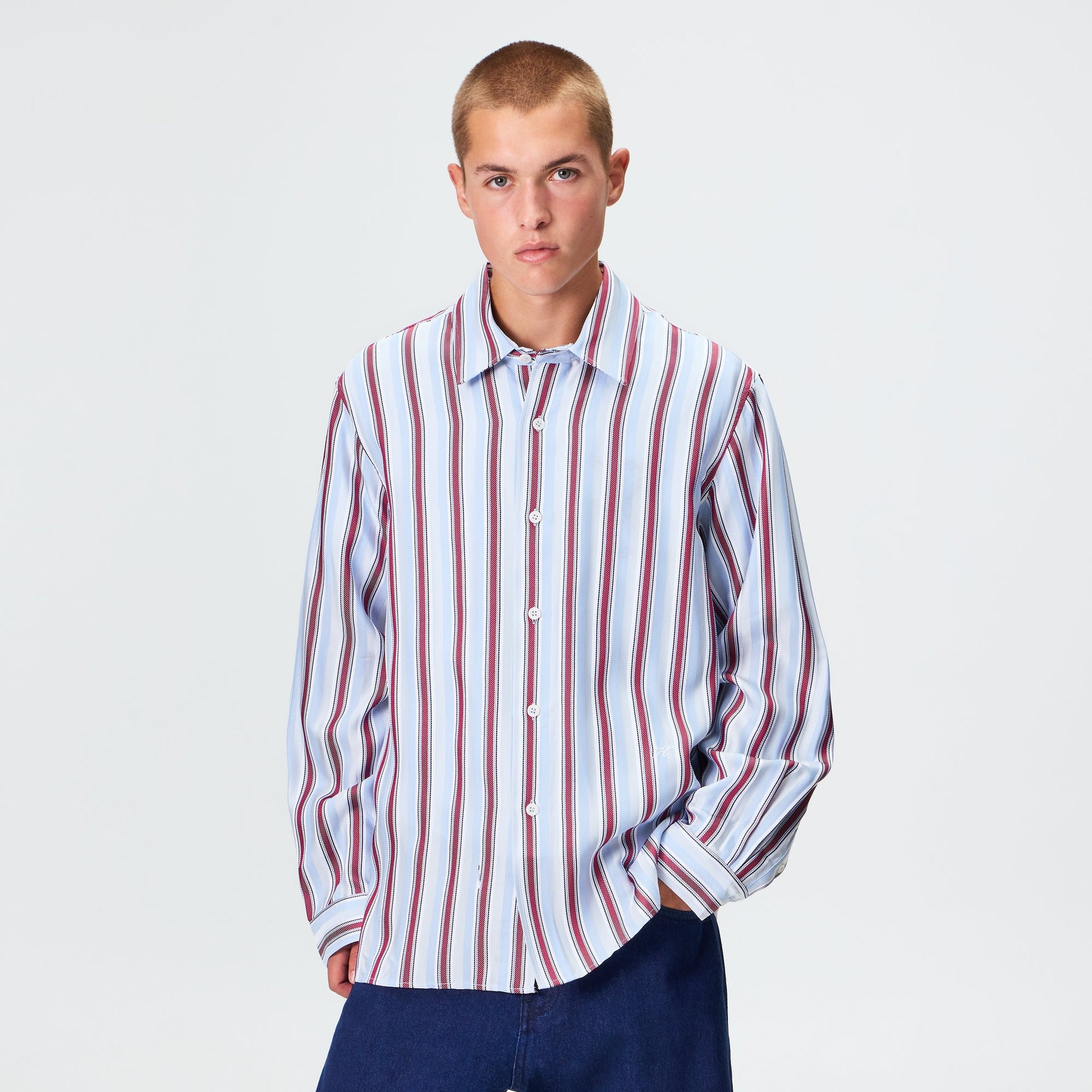 Man wearing the Kith Striped Jacquard Thompson shirt in tin multi-stripe with navy trousers