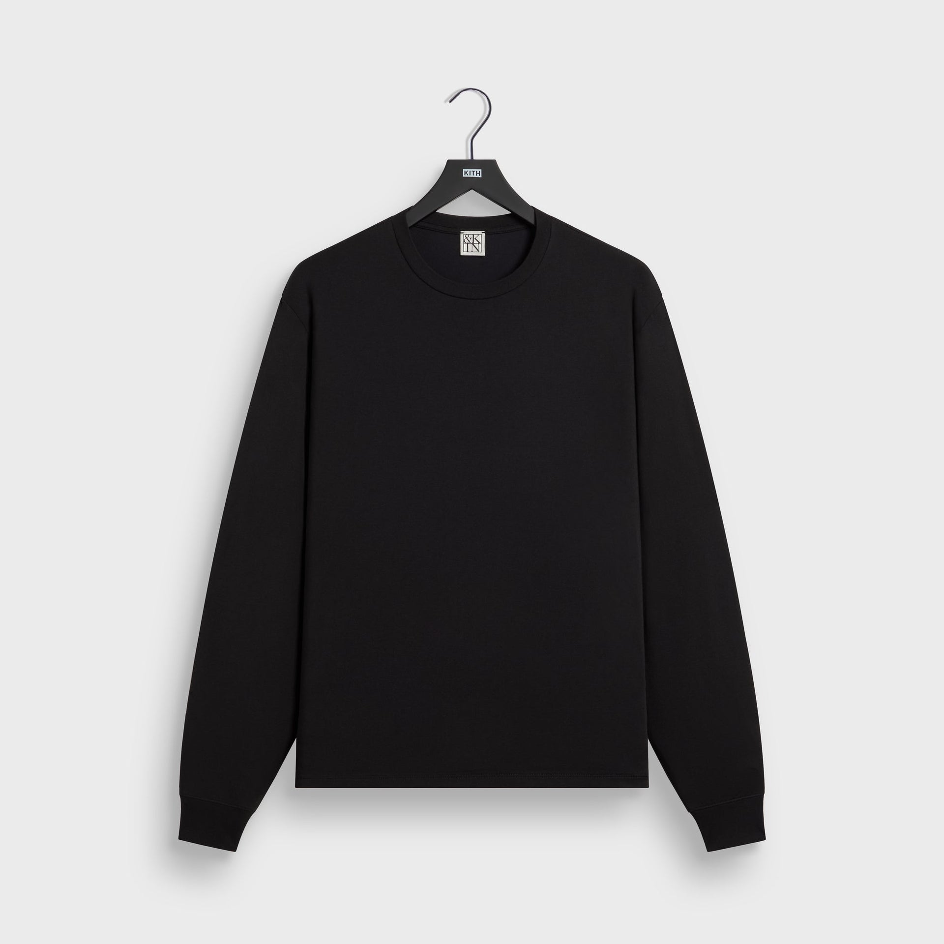 &Kin Long Sleeve Darin Tee in black on a Kith hanger, front view of the crewneck tee