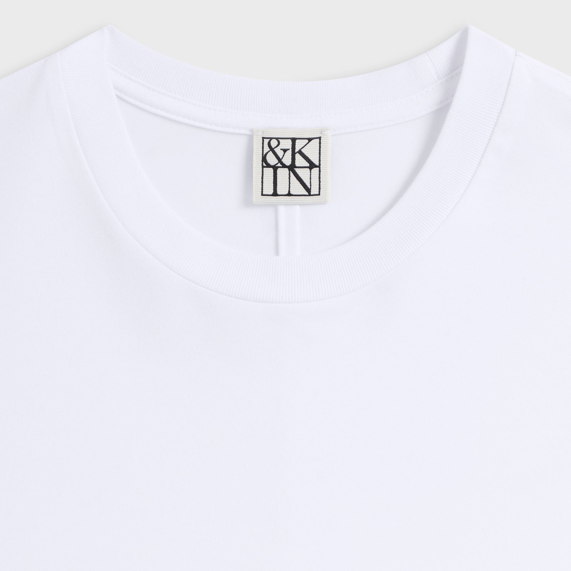 &Kin Darin Tee detail: ribbed crew collar with woven &Kin logo label on white cotton