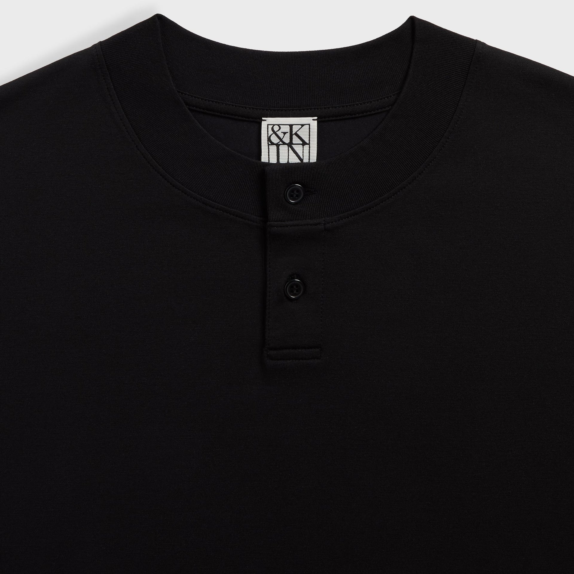 &Kin Albie Henley Tee placket close-up with two black buttons and the woven &Kin label