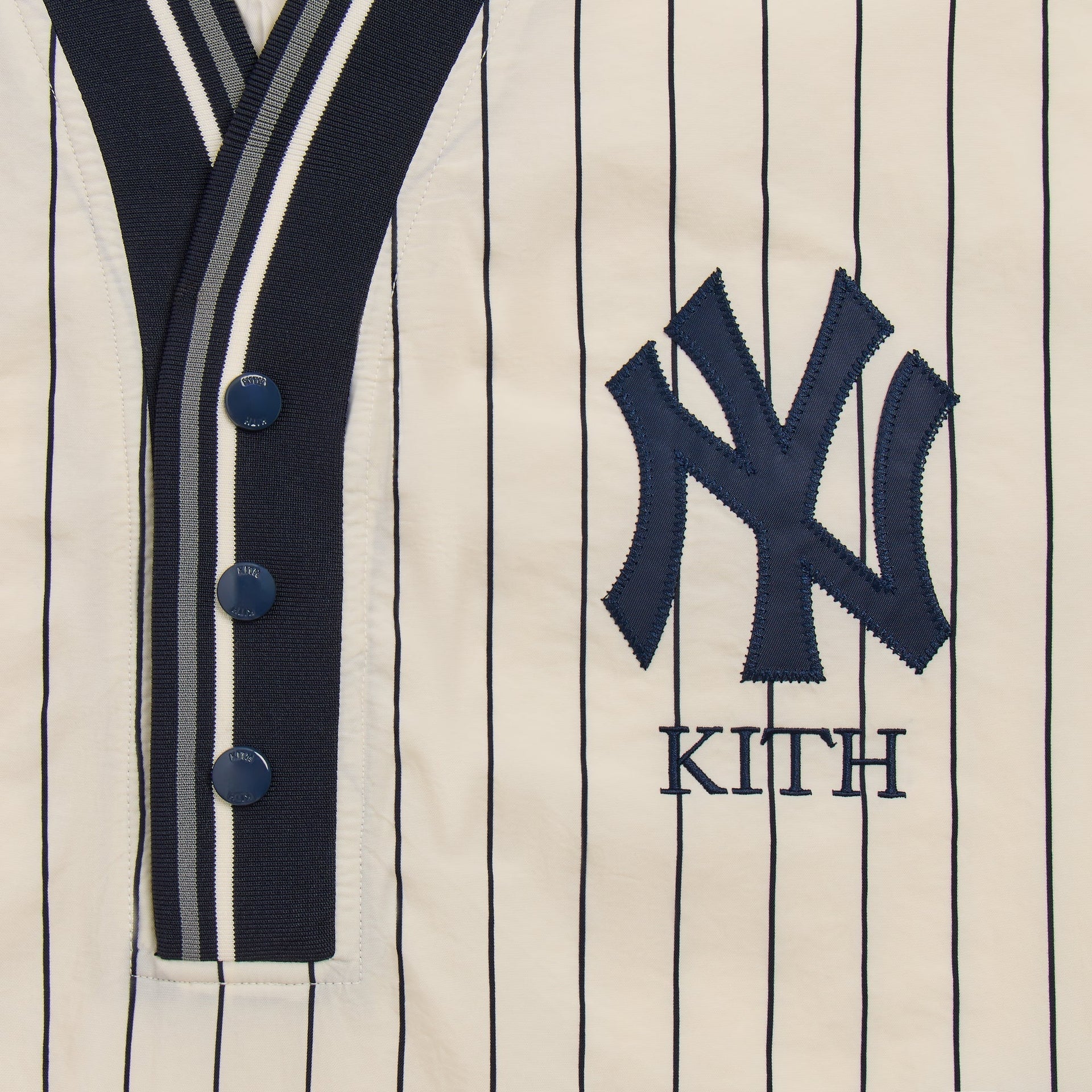 Close-up of NY Yankees and Kith embroidered logo on cream Nylon Raffi pullover placket