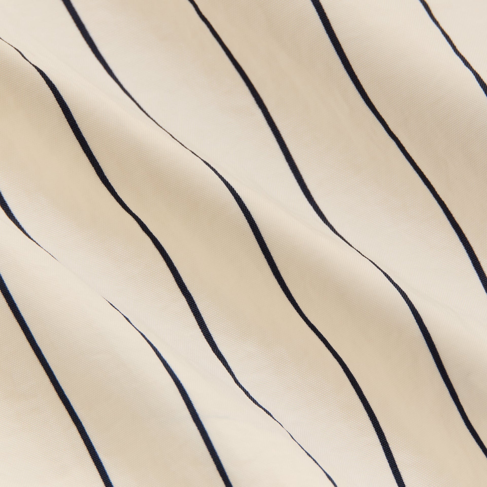Close-up of cream pinstripe nylon fabric texture on the Sandrift Raffi pullover