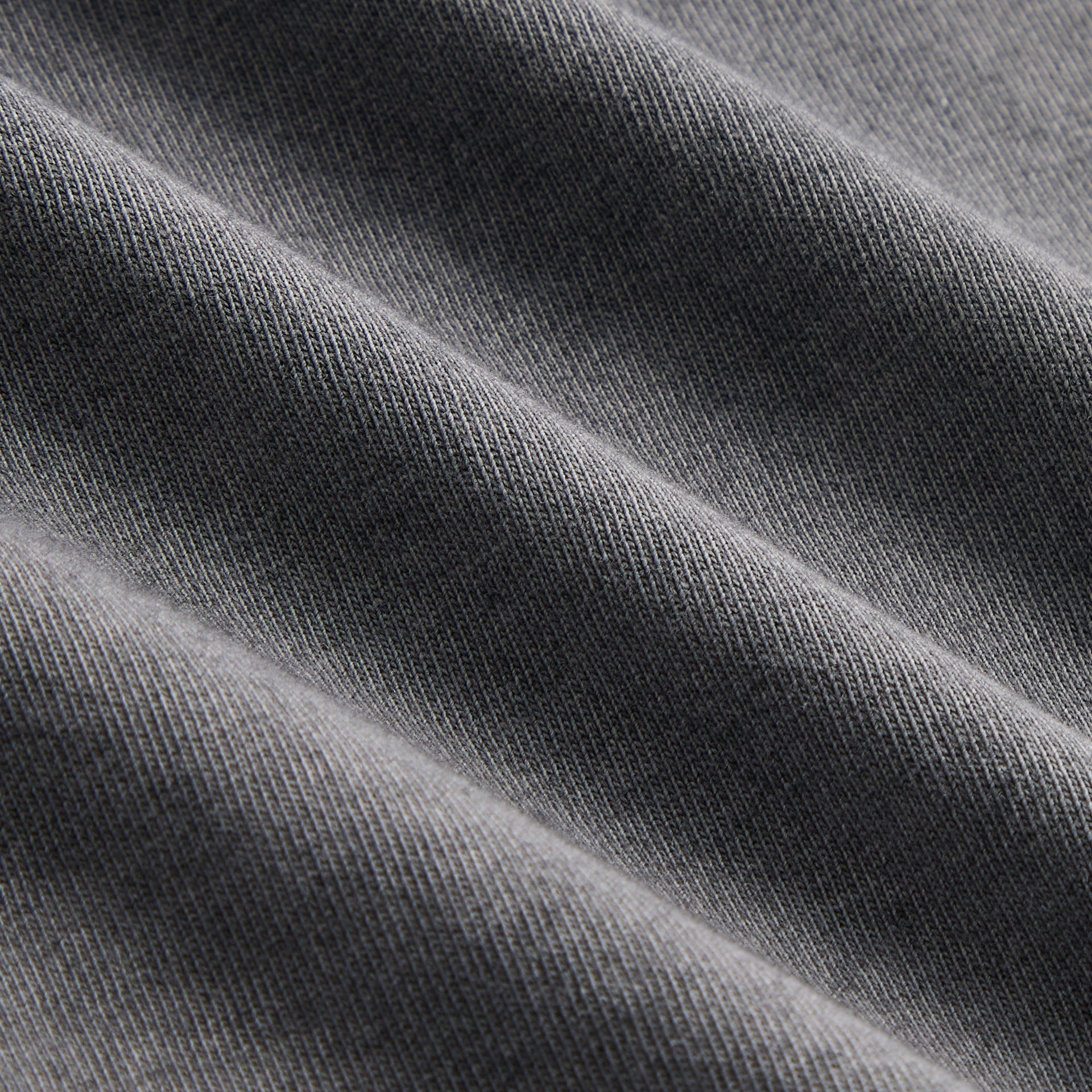 Close-up of the faded black cotton fabric texture on the Kith Jones tee