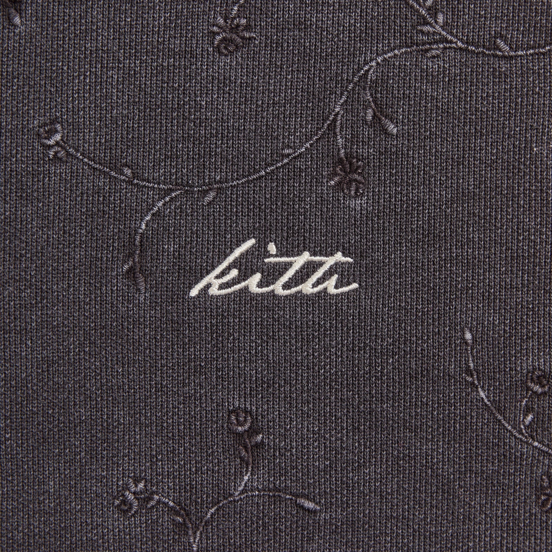 Close-up of the embroidered Kith script logo on the Rose Ivy Nelson hoodie fabric
