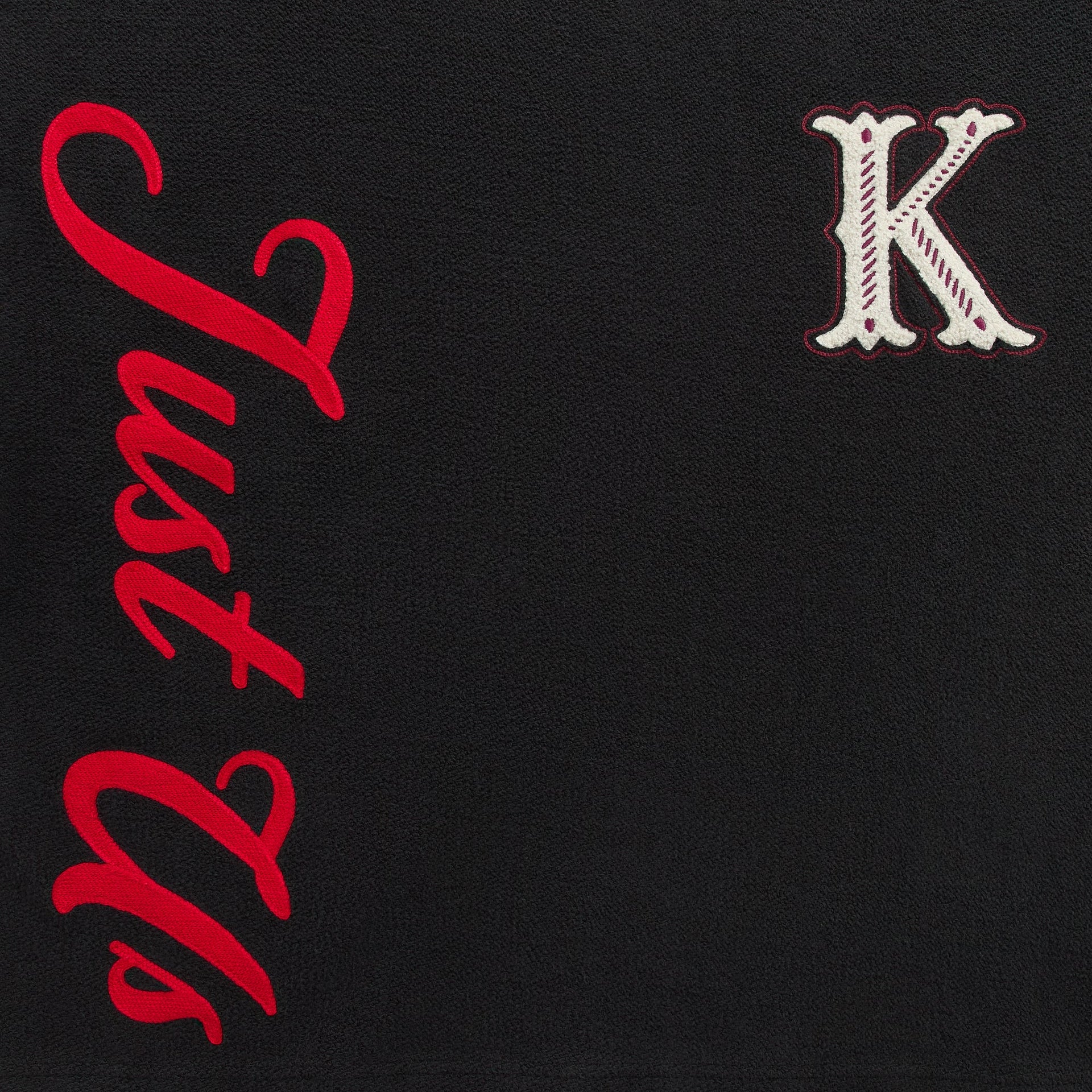 Close-up of the red Just Us embroidery and chenille K patch on the Kith Varsity Lawson crewneck