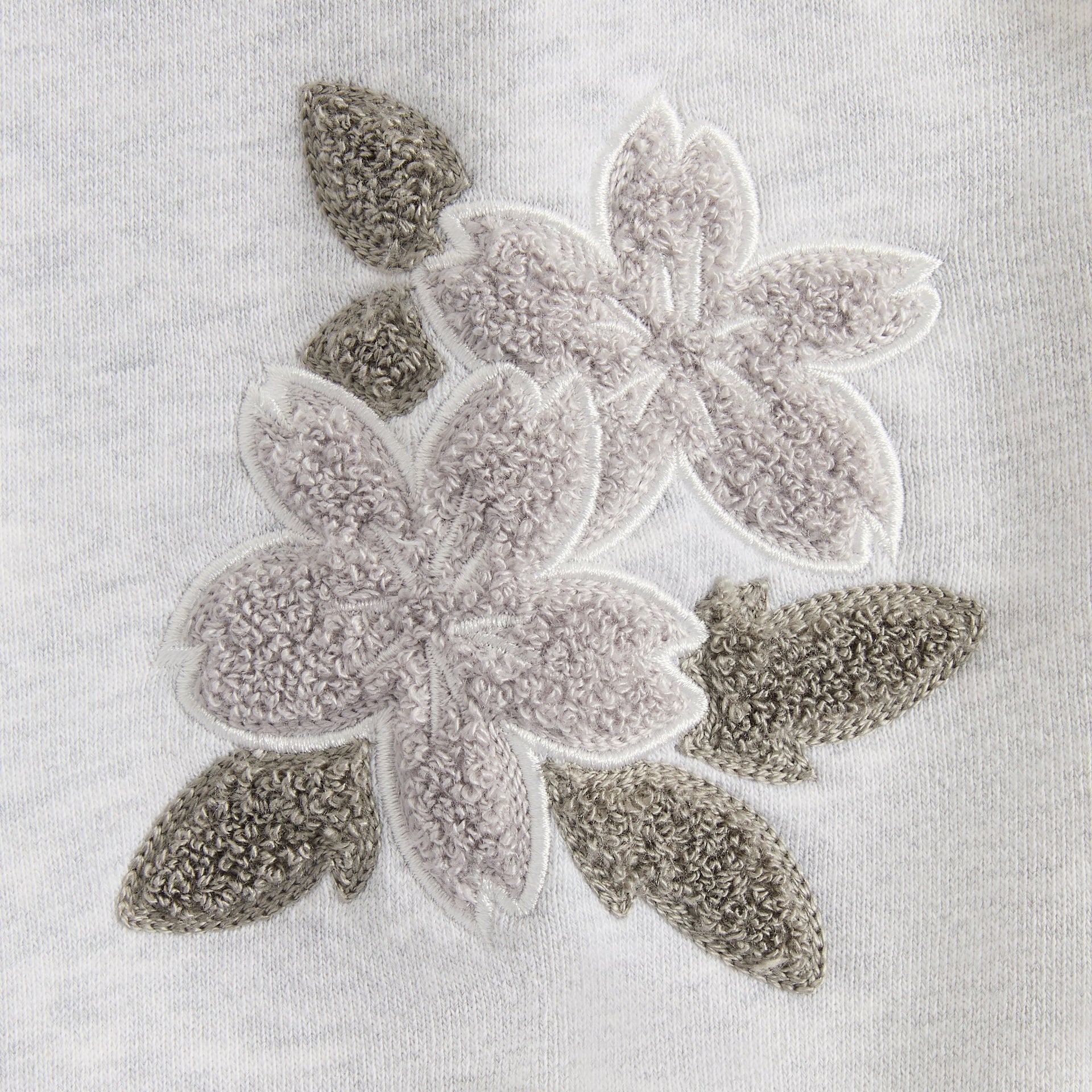 Close-up of the tonal floral chenille embroidery on the light heather grey Lawson crewneck
