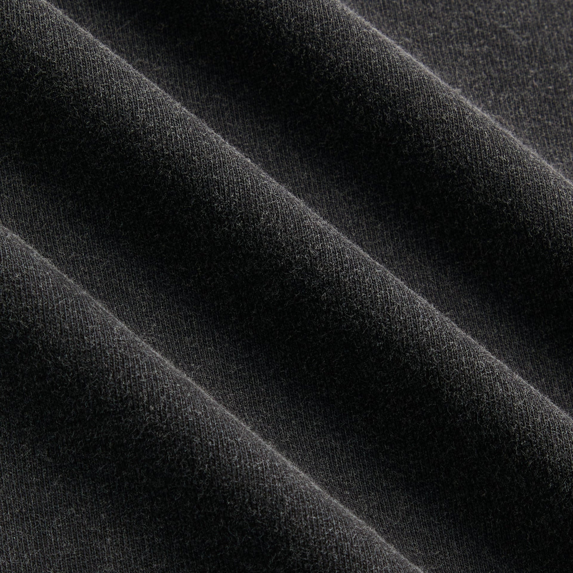 Close-up of the faded black cotton fabric texture on the Kith Guardian Alex boxy vintage tee