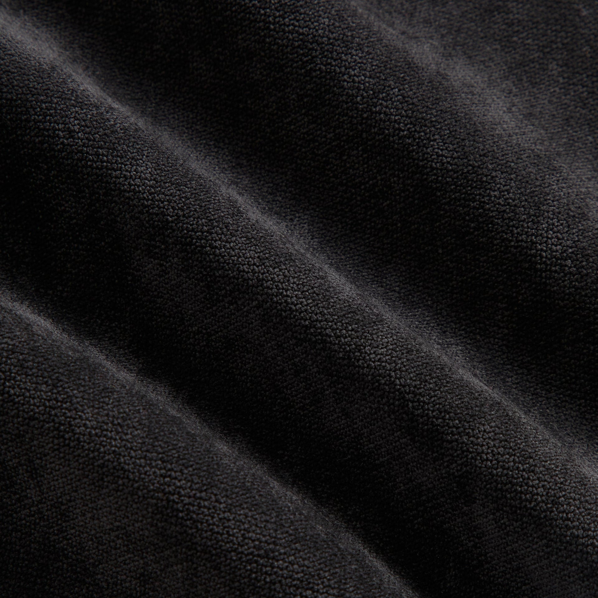 Close-up of the black jersey fabric texture on the Kith NFL Saints Leon shirt