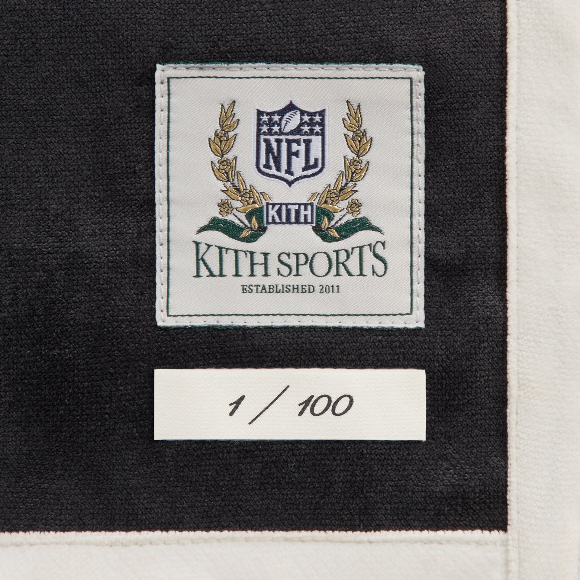 Close-up of the Kith Sports NFL woven label and 1 of 100 numbering tag on the Bengals Leon shirt