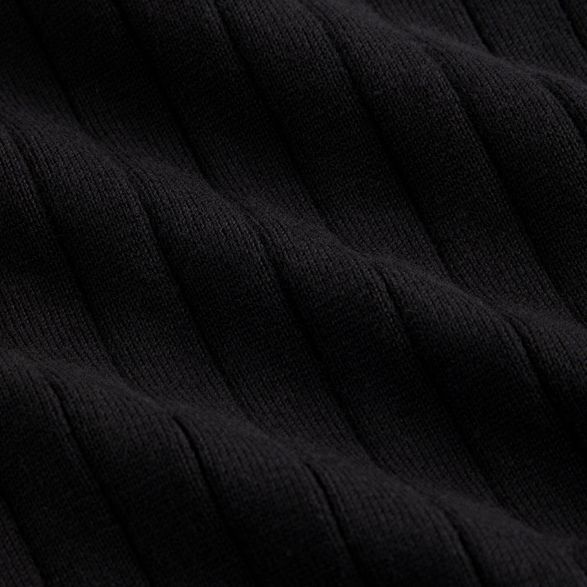 Close-up of black vertical rib knit fabric texture, Kith Ivy Knit Tilden Polo