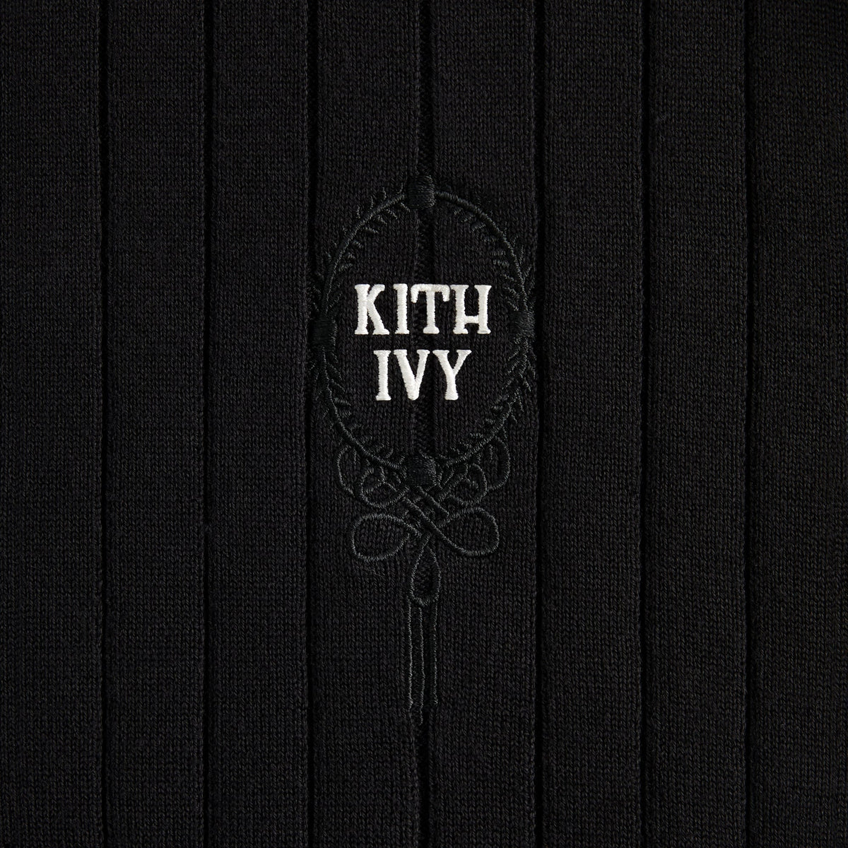 Close-up of cream embroidered KITH IVY crest on black rib knit, Kith Ivy Knit Tilden Polo