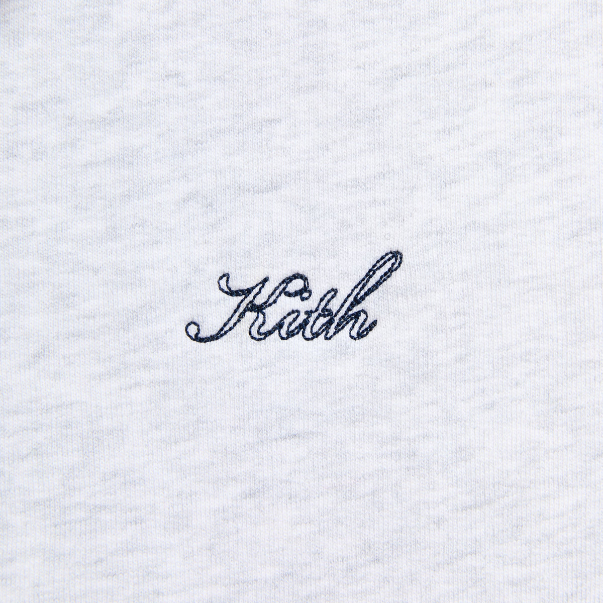 Close-up of the black 'Kith' script on the light heather grey Williams II hoodie