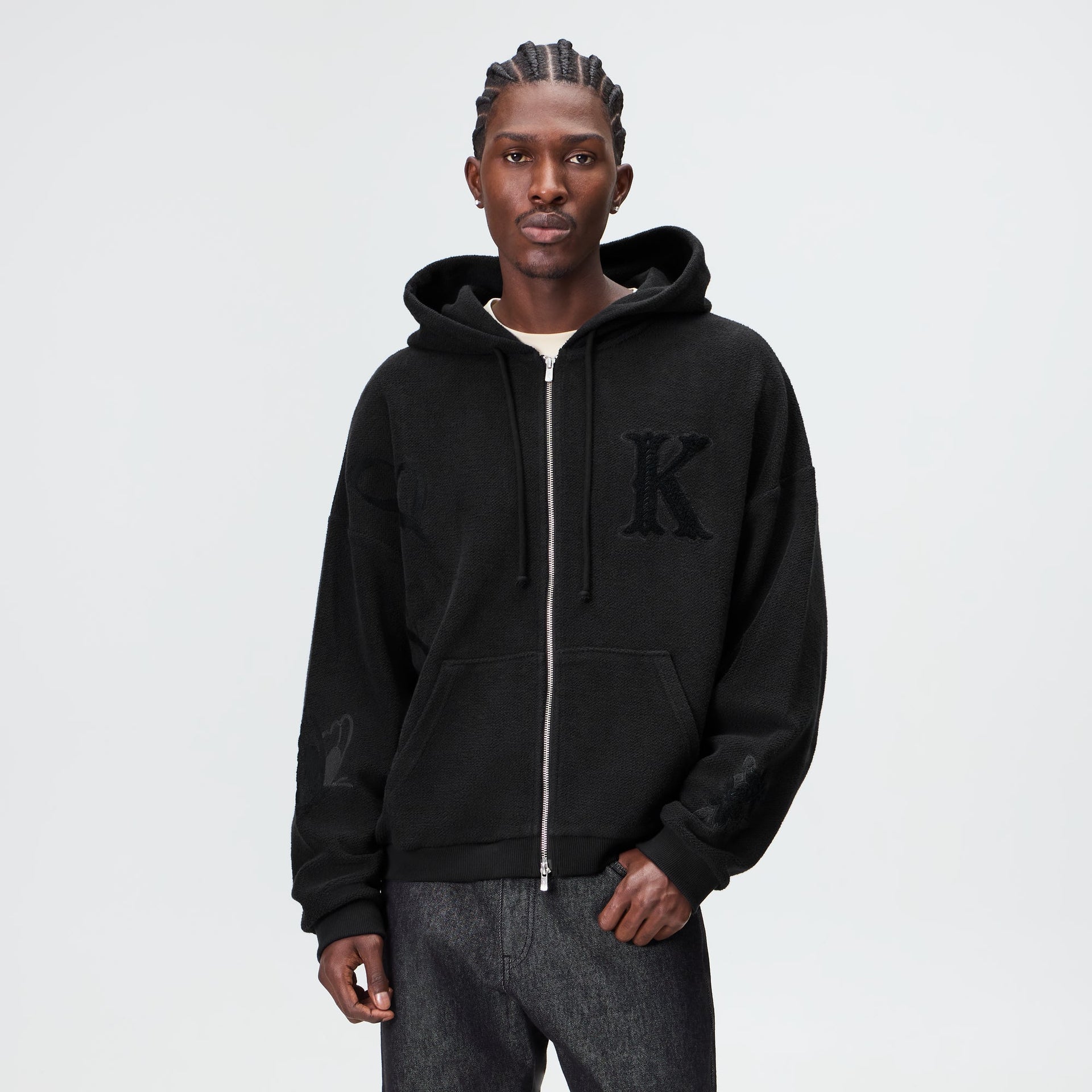 Man wearing the Kith Varsity Braxton hoodie in black fleece with chenille K patch, front view