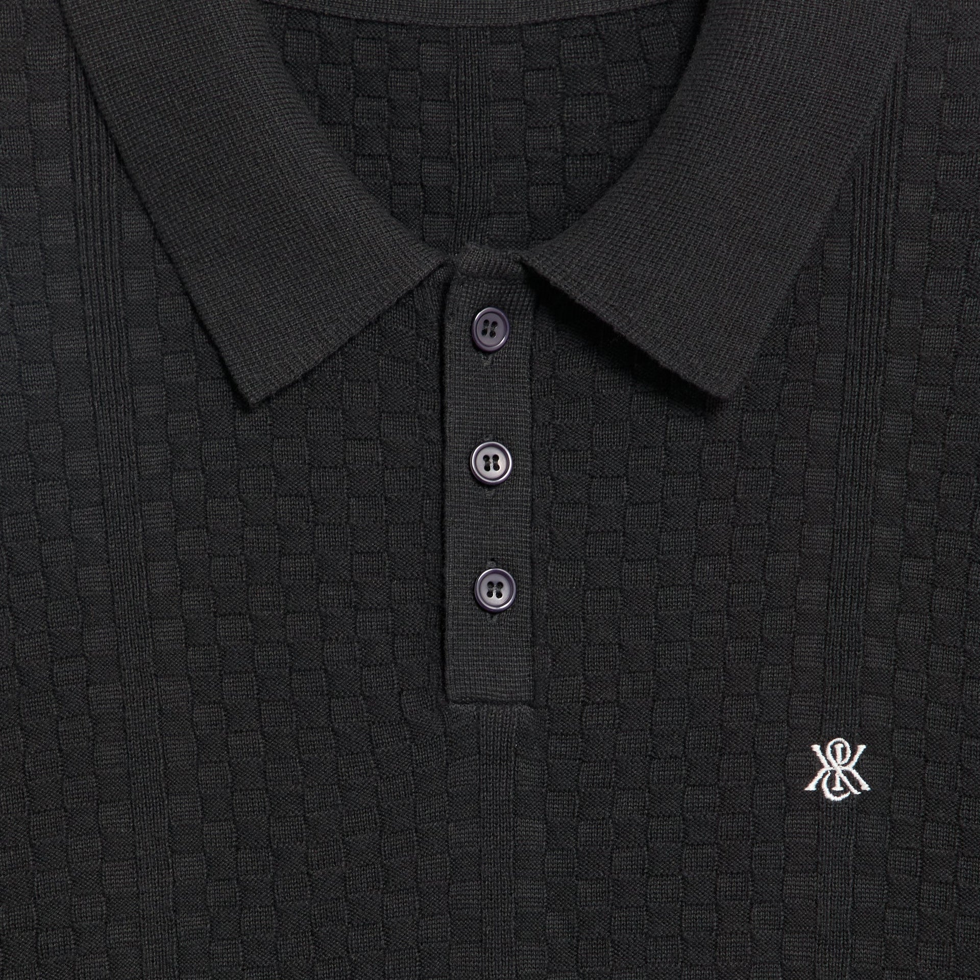 Close-up of the collar, buttons and embroidered logo on the Kith Tilden pullover in black
