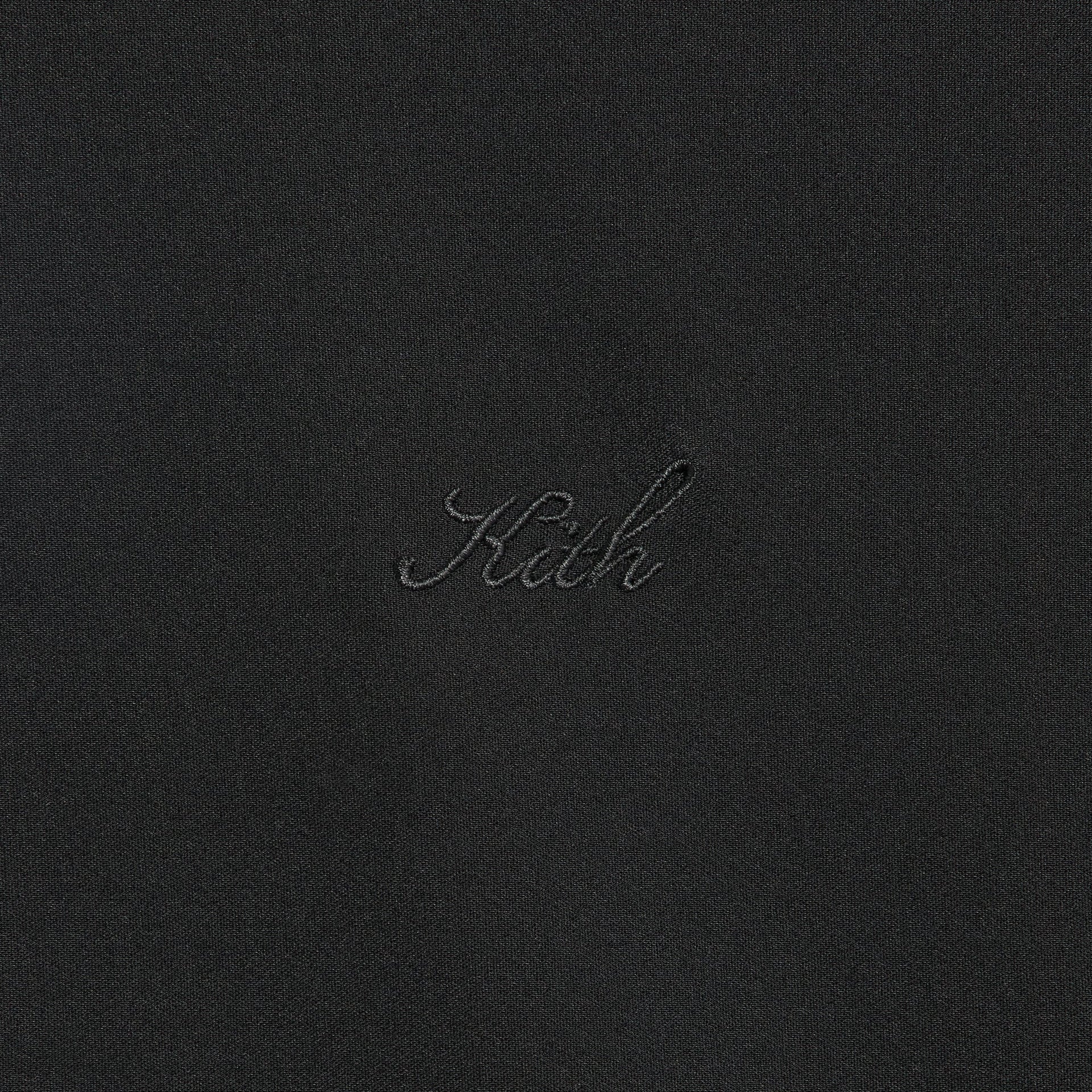 Close-up of the embroidered Kith script logo on the Davis quarter zip pullover in black