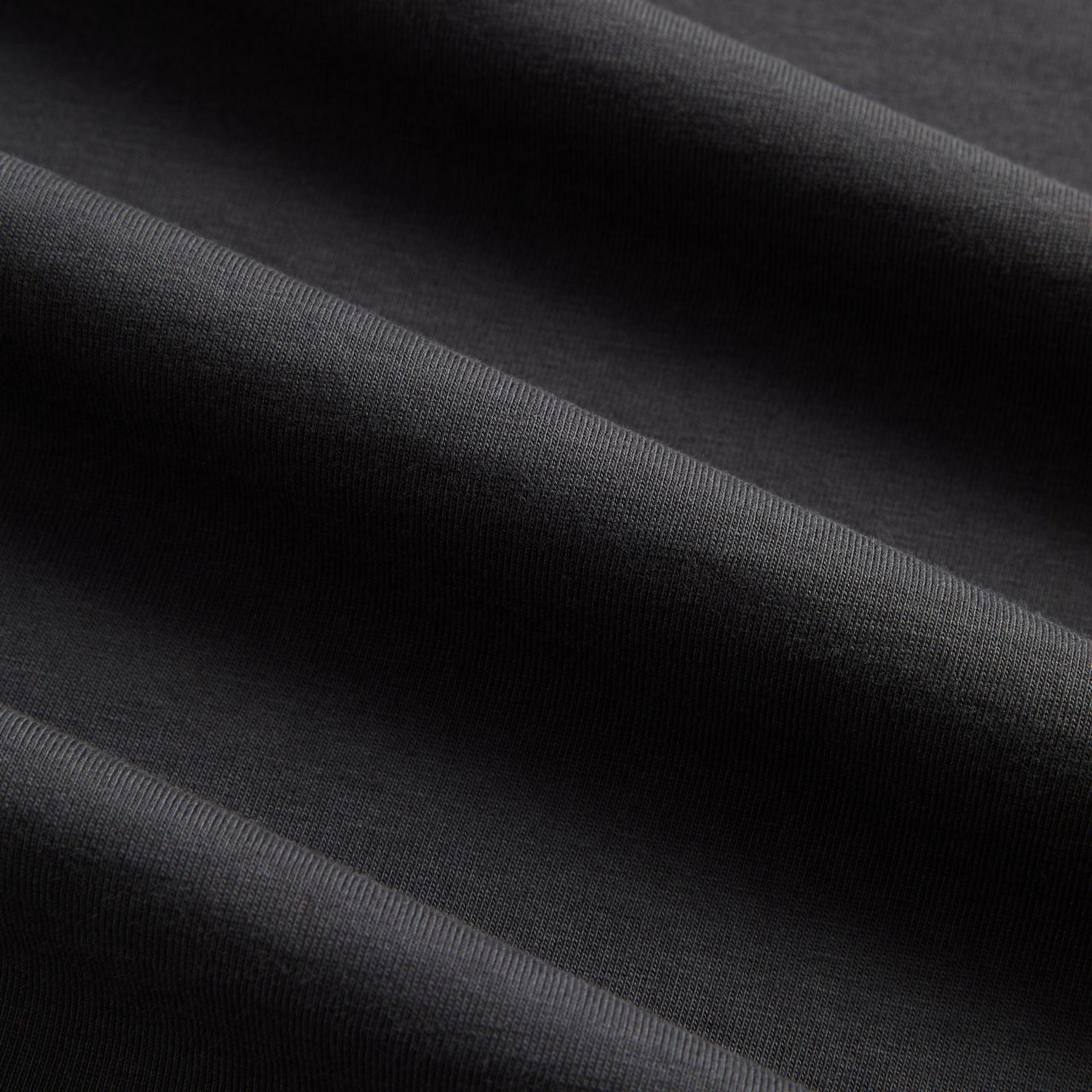 Close-up of the black cotton fabric texture on the Kith LAX tee