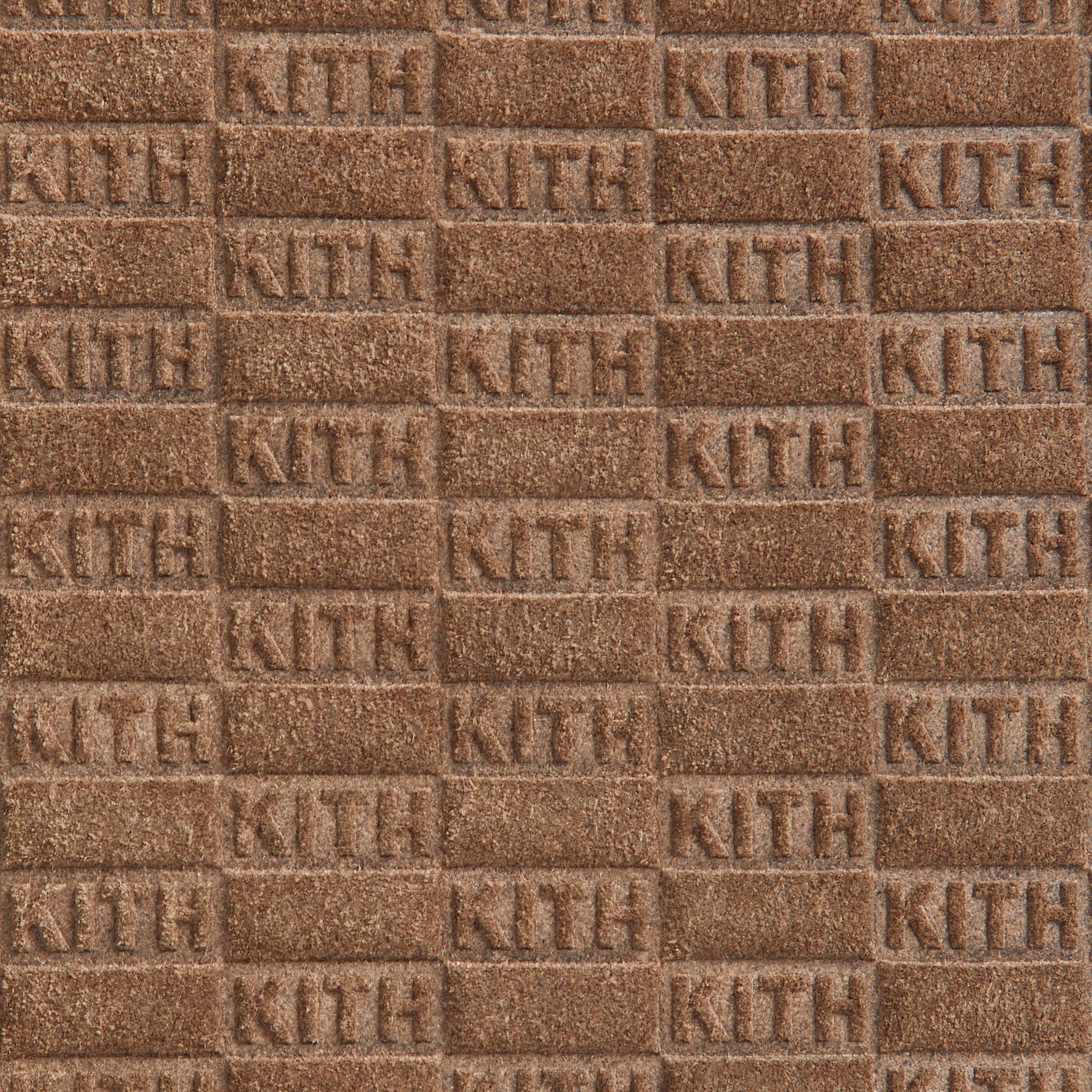 Macro detail of the embossed KITH monogram suede texture on the Drawstring Pouch in Java