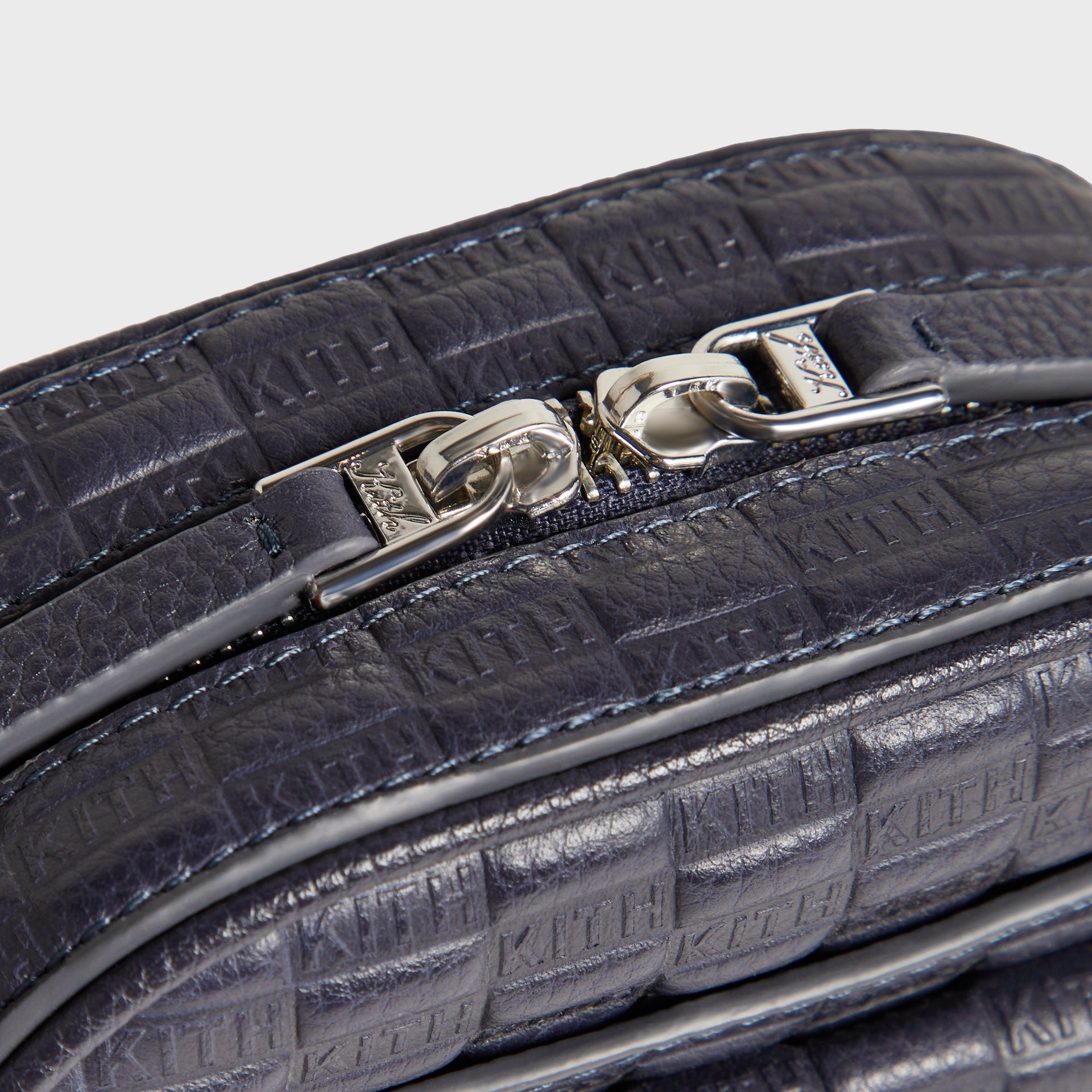 Close-up of the silver-tone zipper pulls on the Kith Monogram Tumbled Leather Passenger K15 Bag in Ink