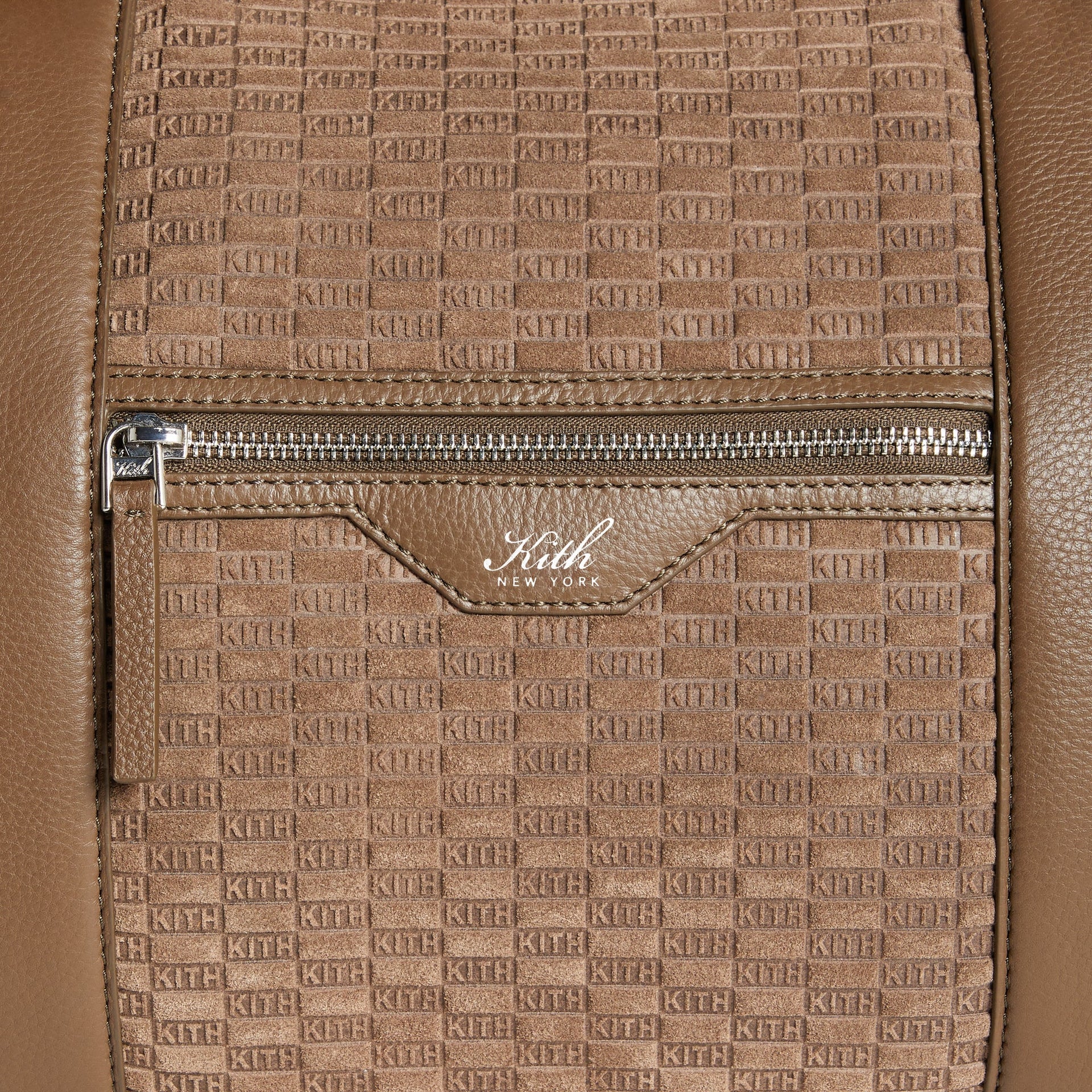 Close-up of front zip pocket with white-foil Kith New York logo on the Suede Traveler K55 Duffle Bag