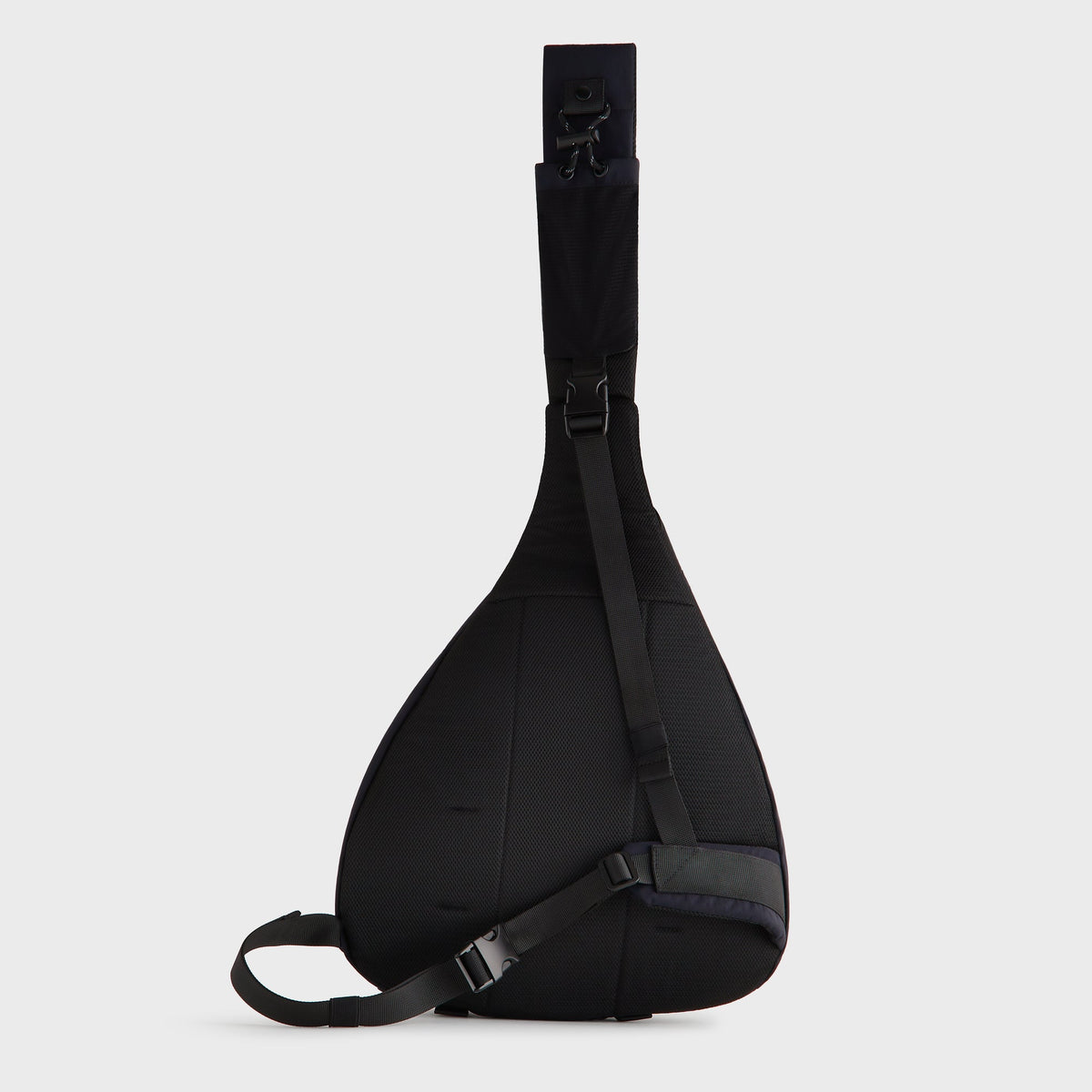 Kith Nylon Ripstop Sling Backpack in black, rear view with diagonal mesh strap and clip buckle