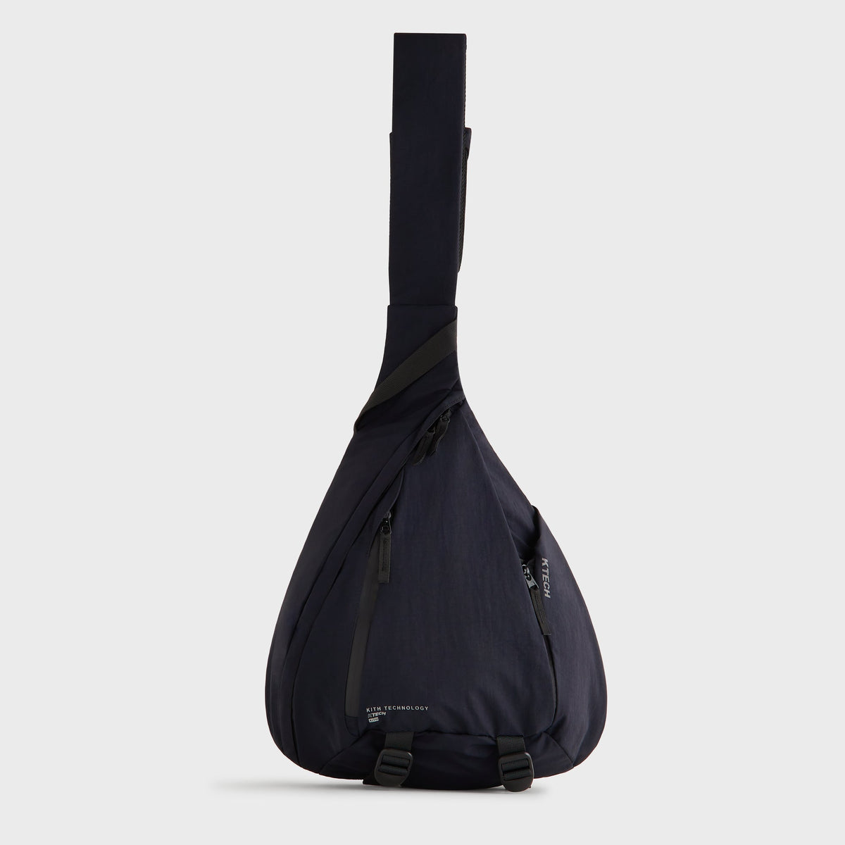 Kith Nylon Ripstop Sling Backpack in black, full side view showing mesh strap and buckles