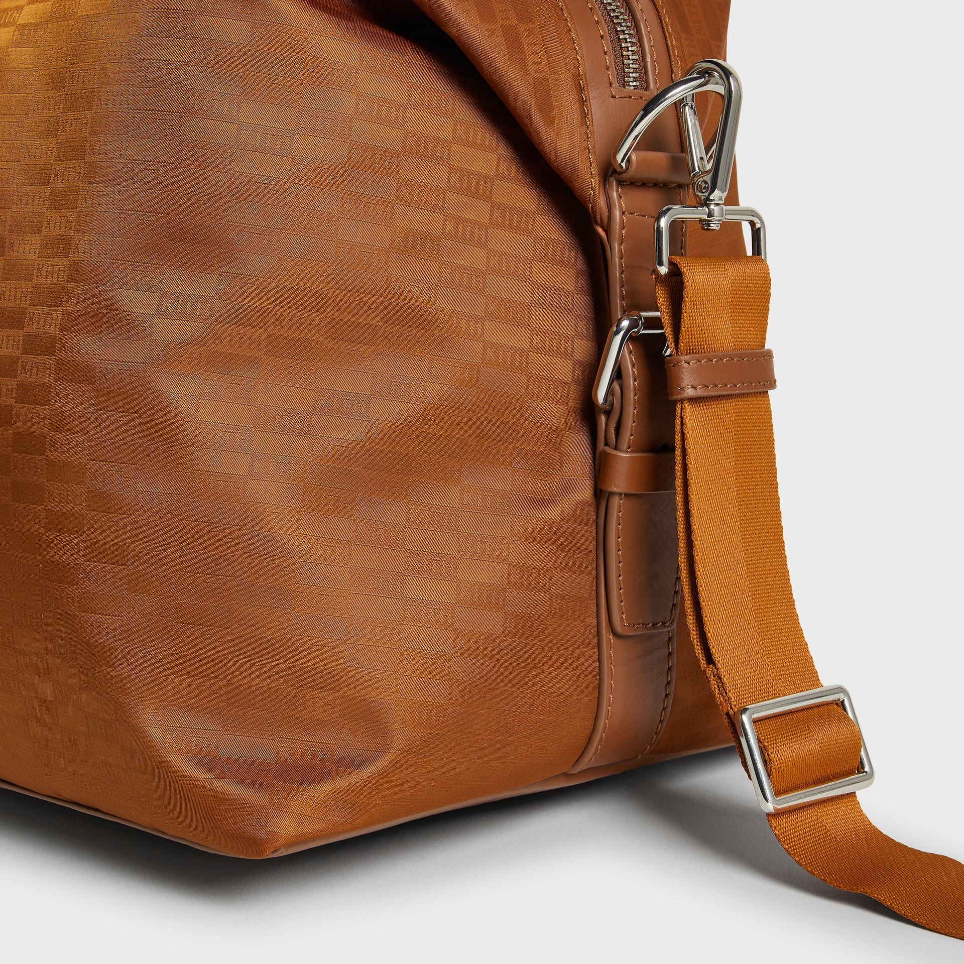 Kith Monogram Nylon Leather Duffle Bag in Tectonic, detail of side hardware, D-ring clasps and strap attachment