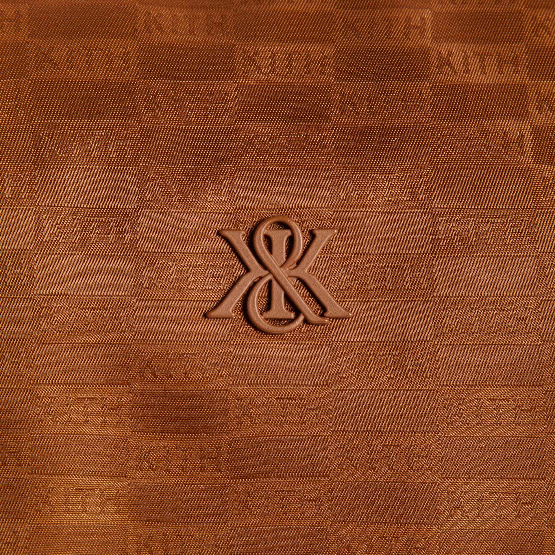 Kith Monogram Nylon Leather Duffle Bag in Tectonic, close-up of embossed K&K logo on jacquard nylon fabric
