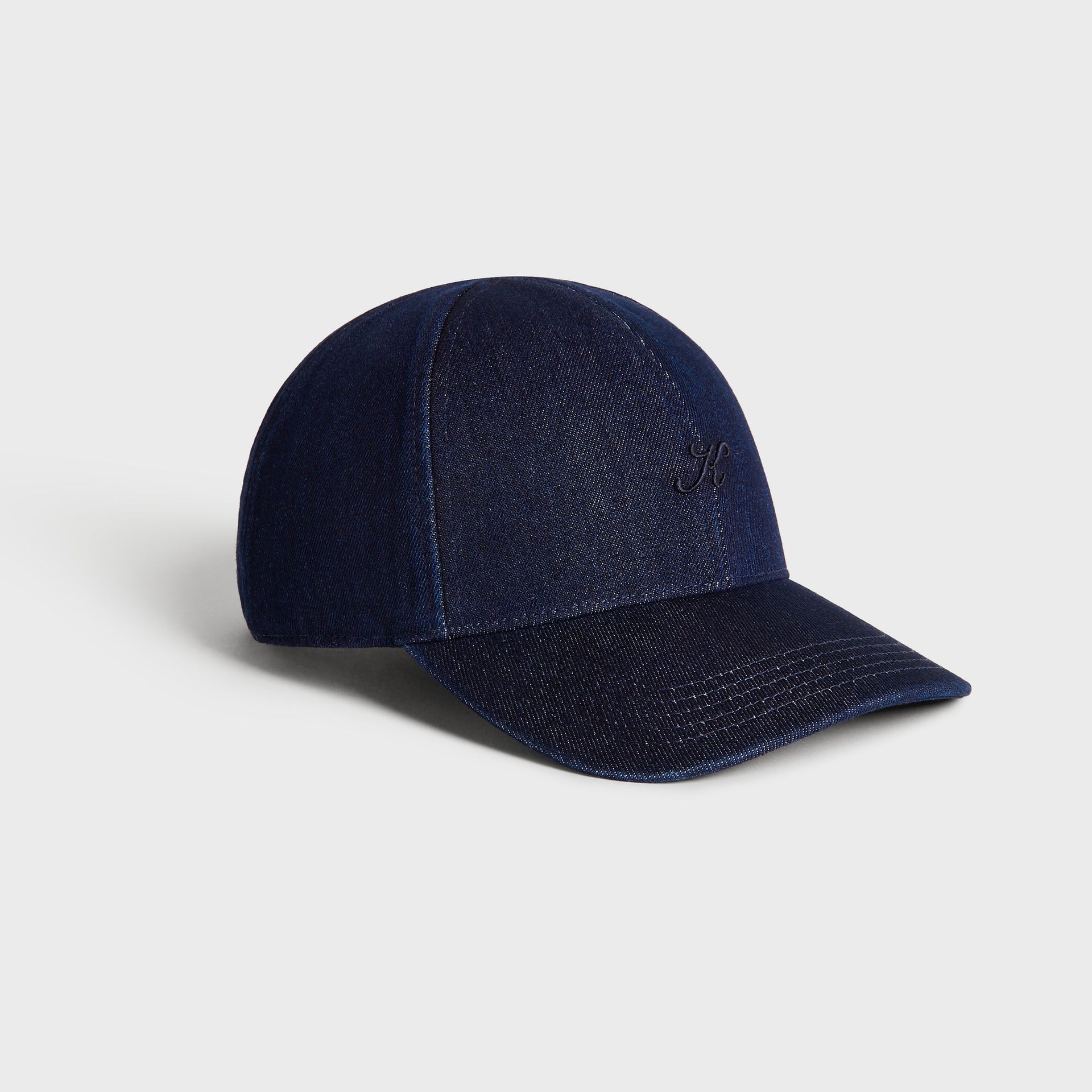 Three-quarter angle view of the Kith Low Profile Raw Denim Classic Cap in Savin Wash denim with curved brim and low-profile crown