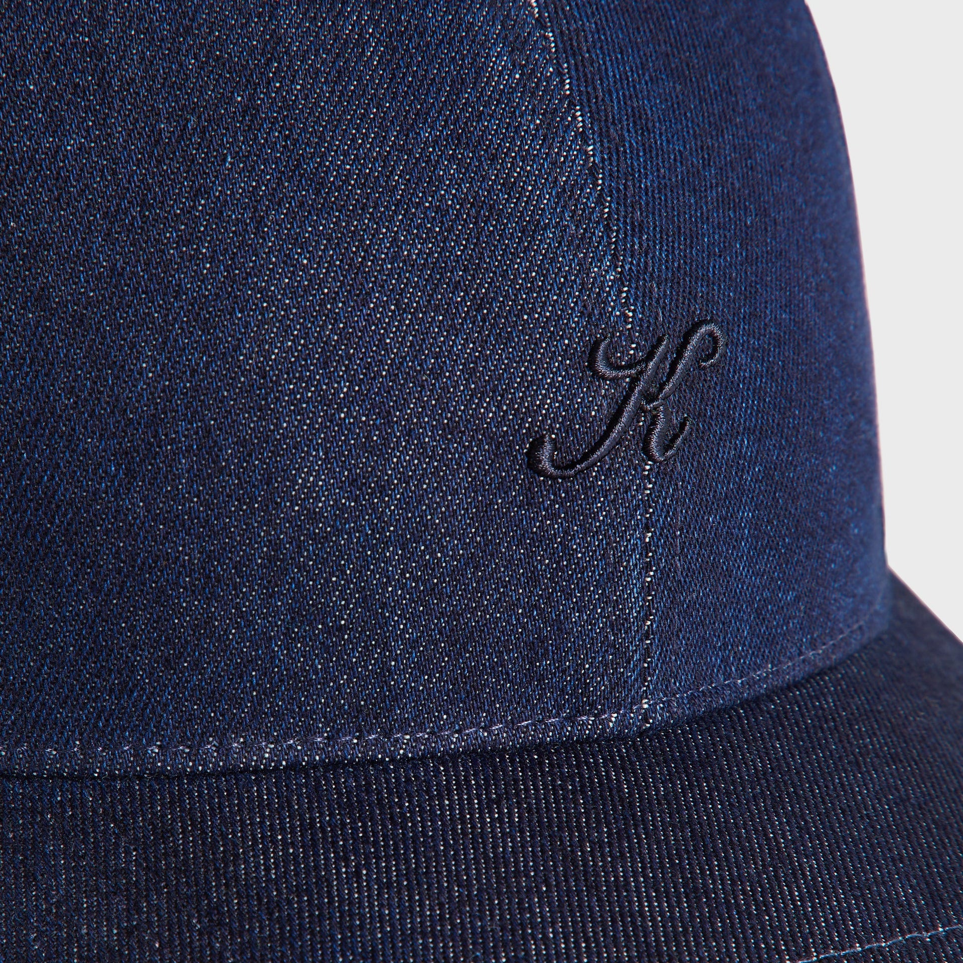 Close-up detail of the Kith Low Profile Raw Denim Classic Cap in Savin Wash showing the embroidered K logo and raw denim twill texture