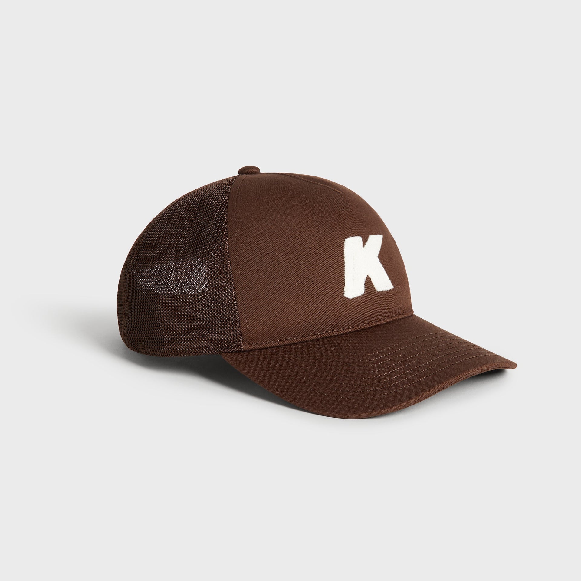 Kith Relaxed Twill Nolan Trucker Hat in Kindling, three-quarter angle view highlighting curved brim and K patch