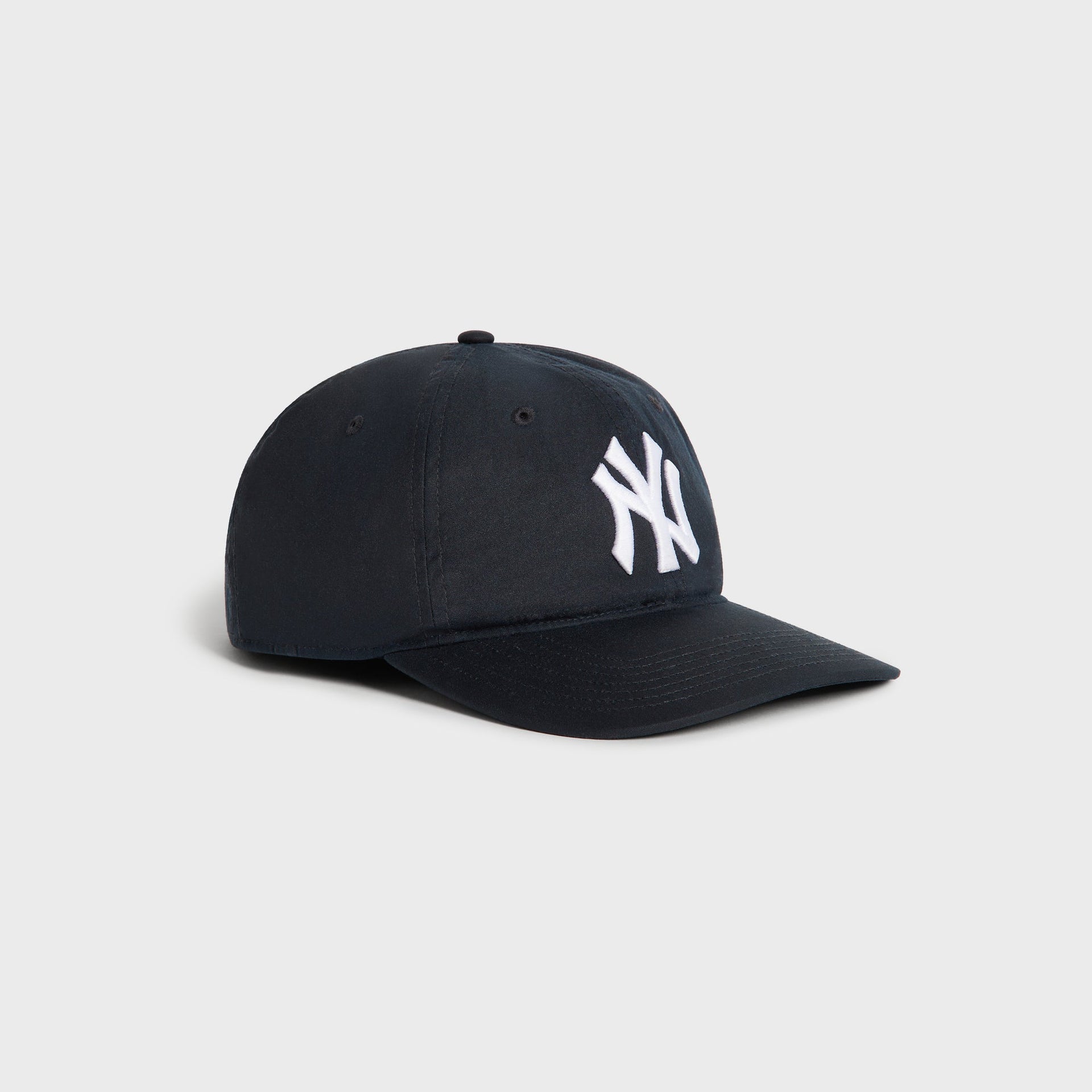 Kith & '47 Yankees Waxed Cotton cap in navy Nocturnal, three-quarter angle showing the crown and curved brim.