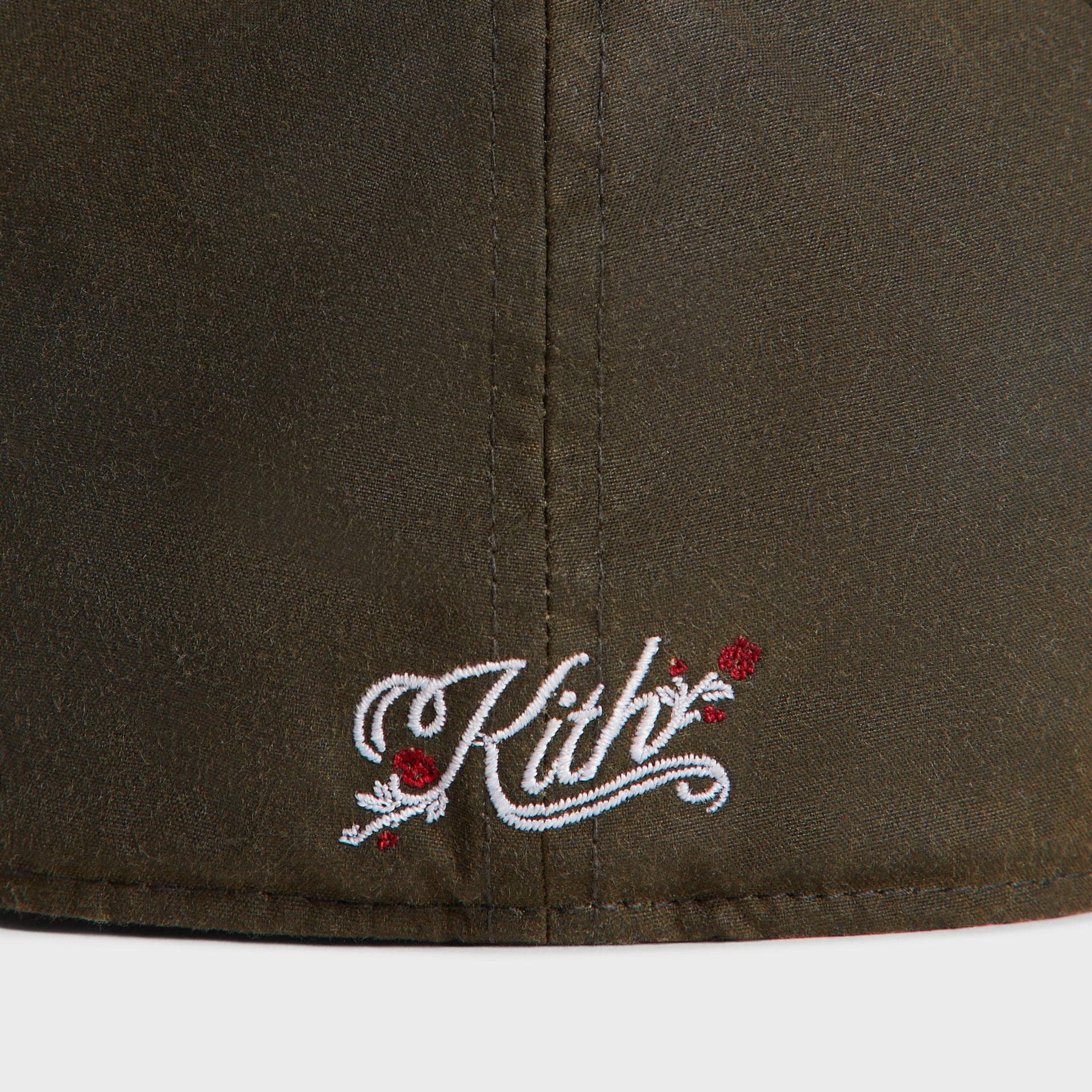 Close-up of the white-and-red Kith rose-script embroidery on the back of the olive Cypress Dodgers cap.
