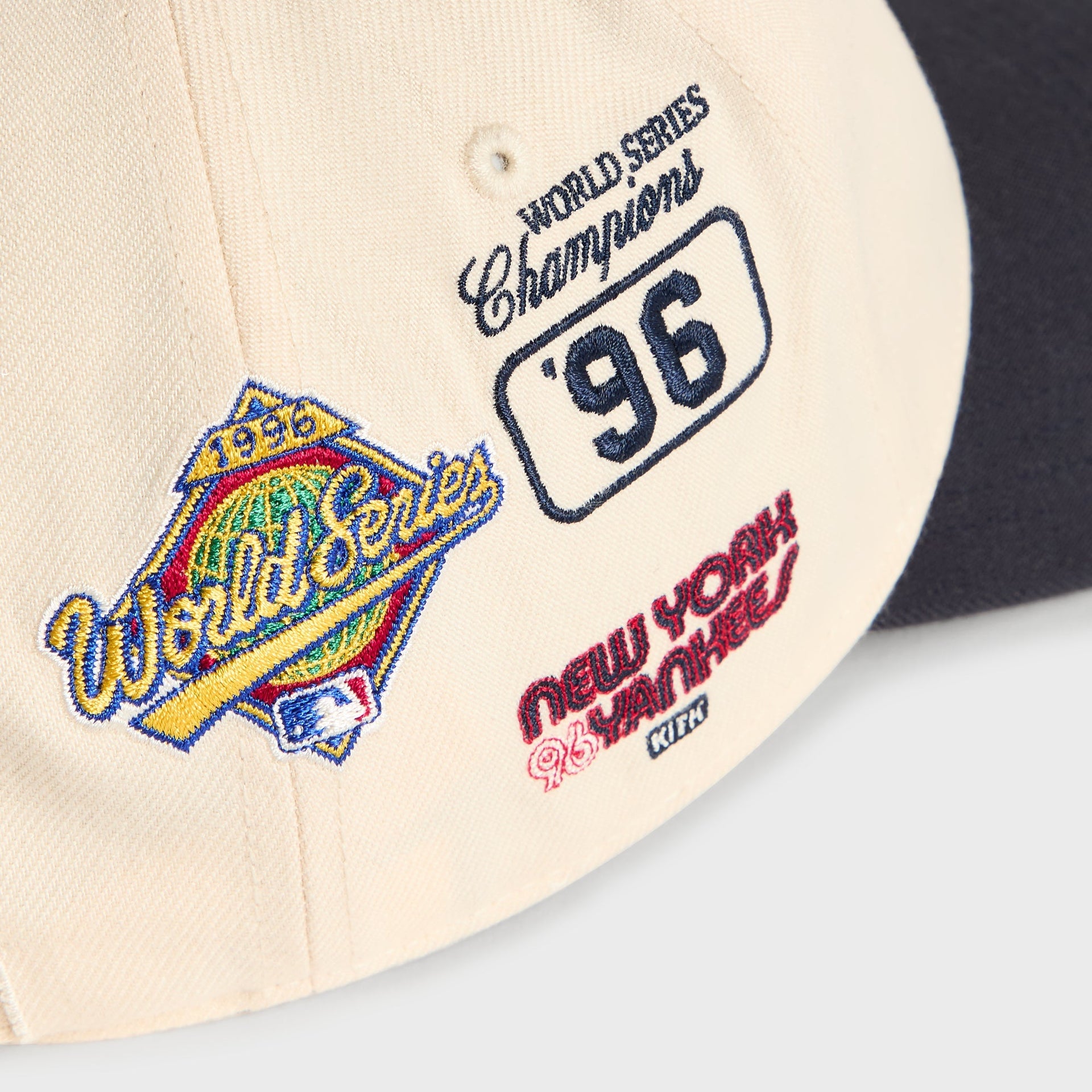 Detail of left-side patches: World Series diamond logo and New York Yankees text on Sandrift cap