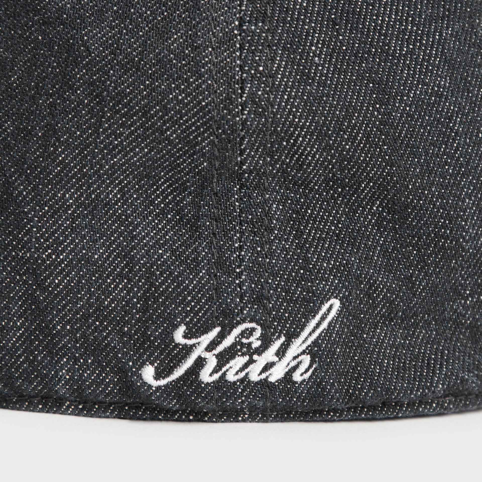 Close-up detail of Kith script logo embroidery on back of Denim Franchise cap in Black