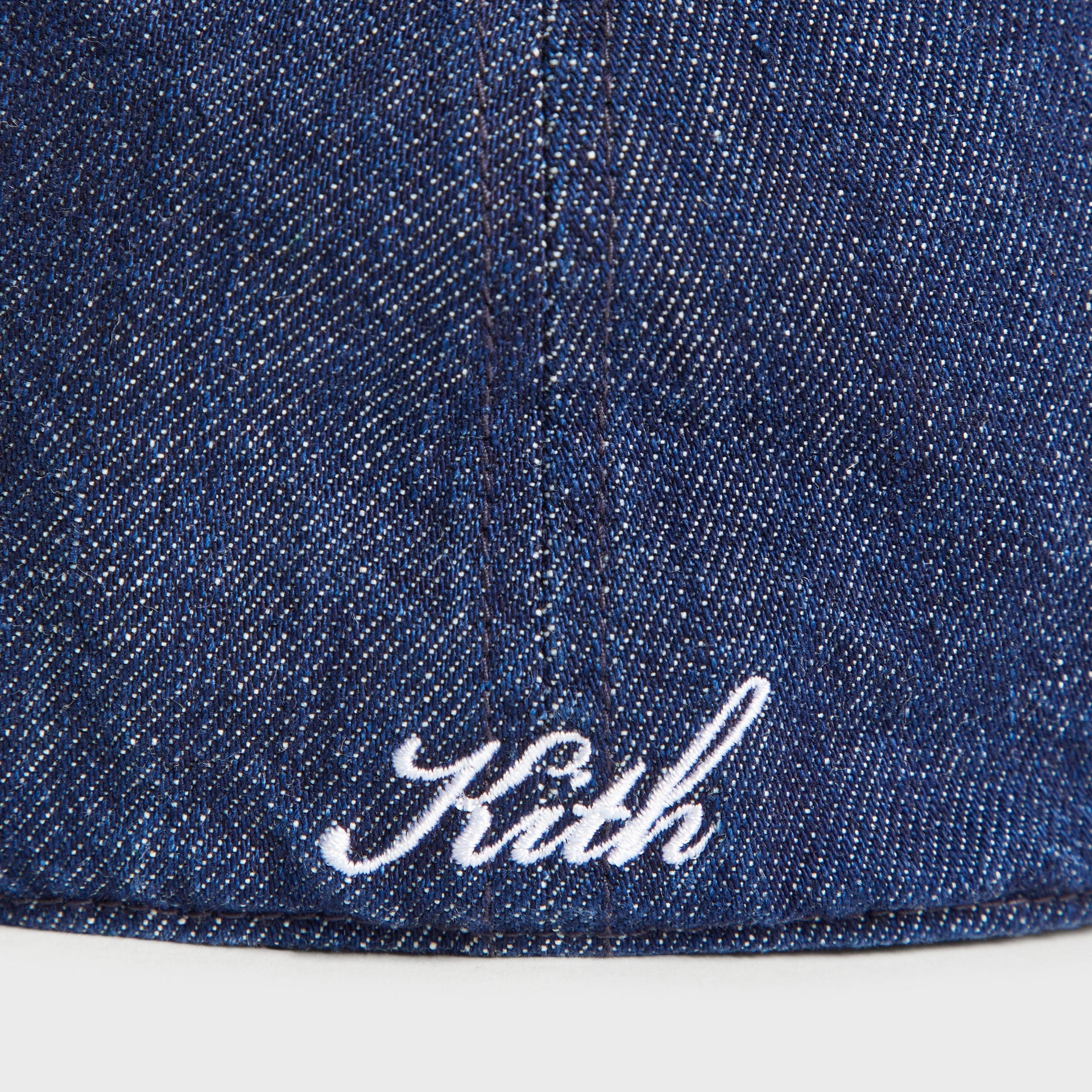 Close-up of the Kith script logo embroidered in white on the denim of the Yankees Franchise Cap