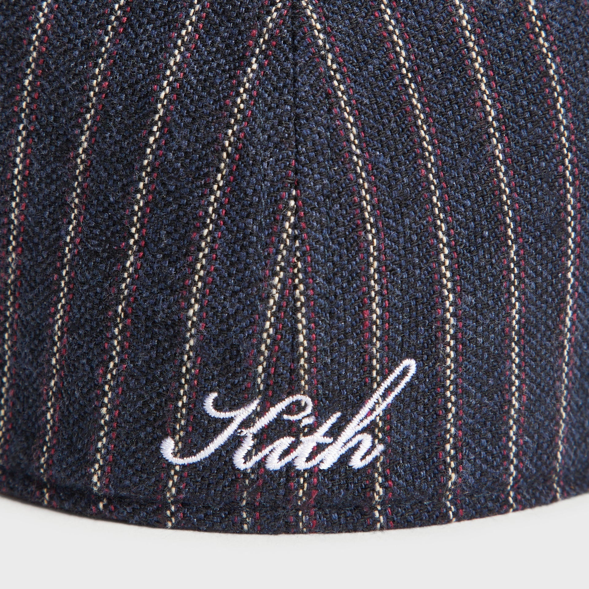 Close-up detail of Kith script logo embroidery on back of Barre Stripe Franchise cap in Nocturnal