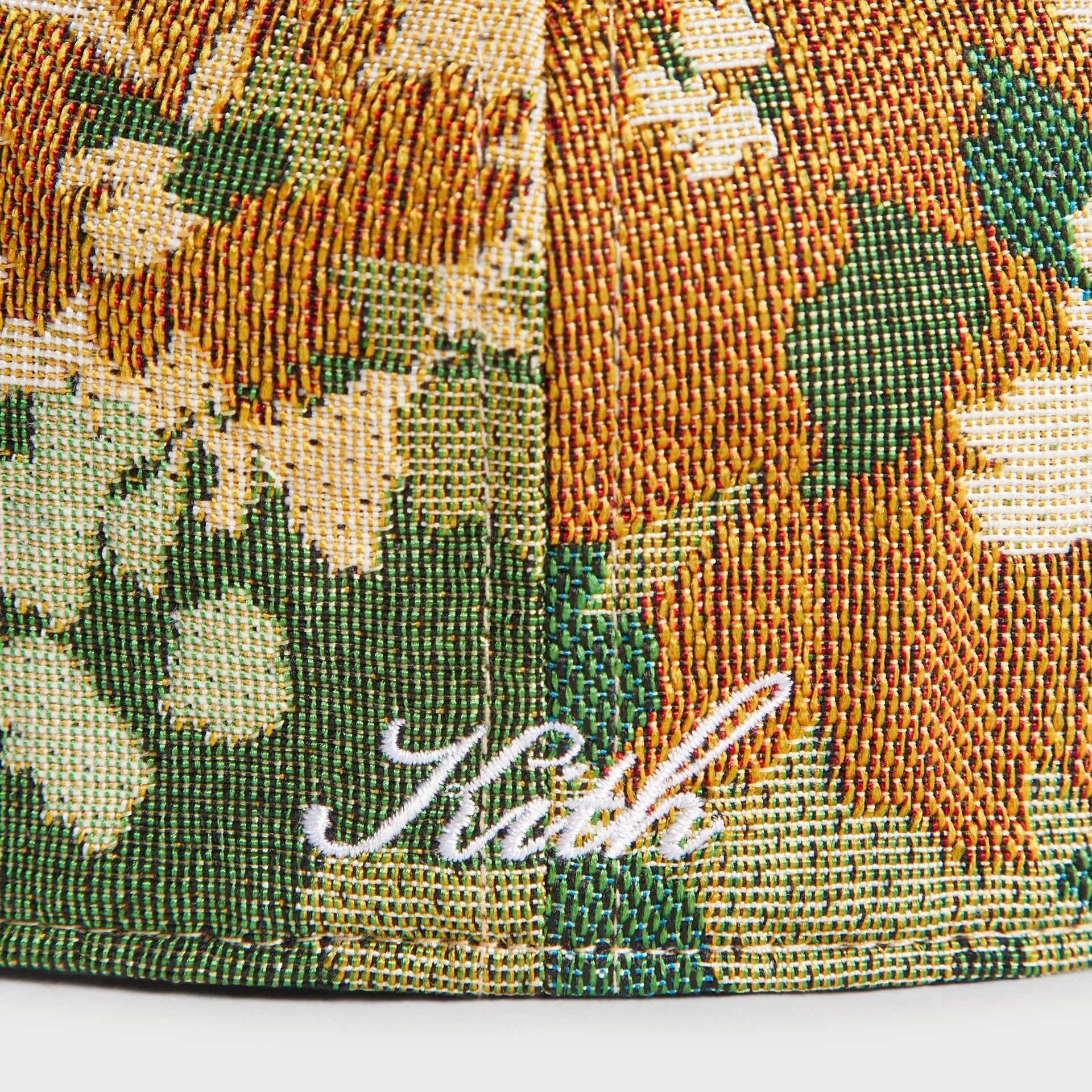 Macro detail of the floral jacquard tapestry weave and Kith script signature on the Sage ‘47 Franchise Cap