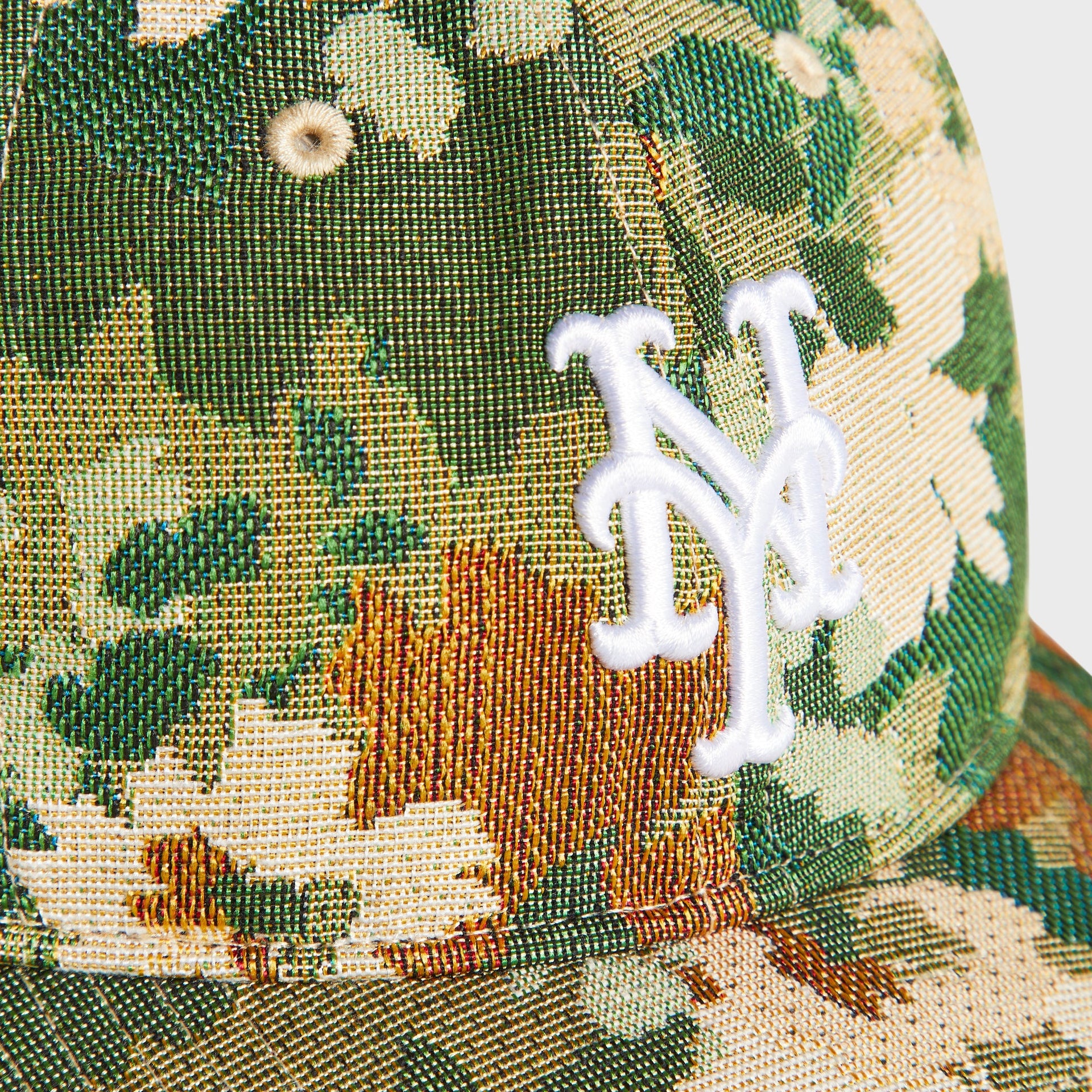 Close-up of the white embroidered NY Mets interlocking logo on the Sage tapestry Kith & ‘47 Franchise Cap