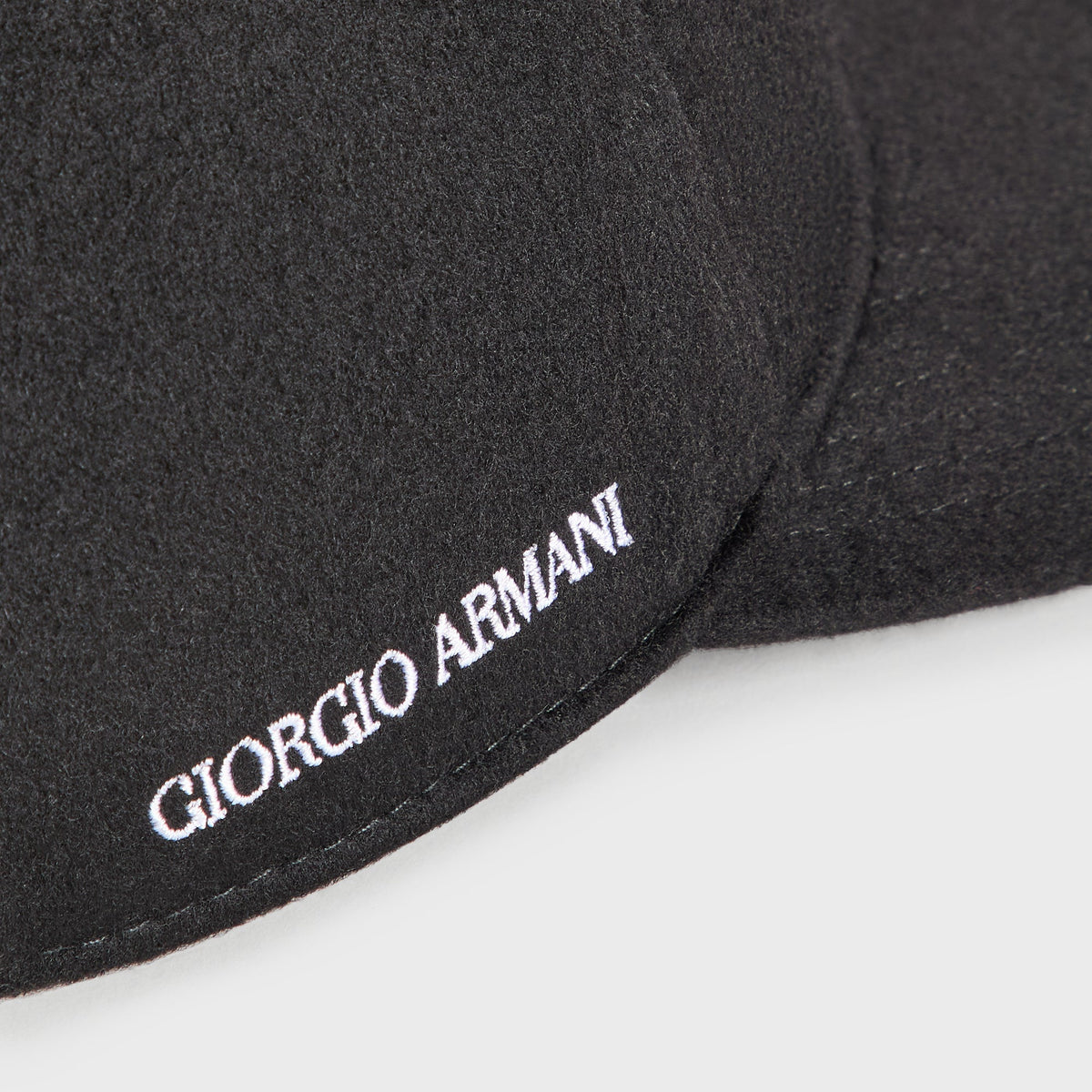 Close-up of white Giorgio Armani embroidery on the side of the Giorgio Armani & Ronnie Fieg for '47 black wool cap