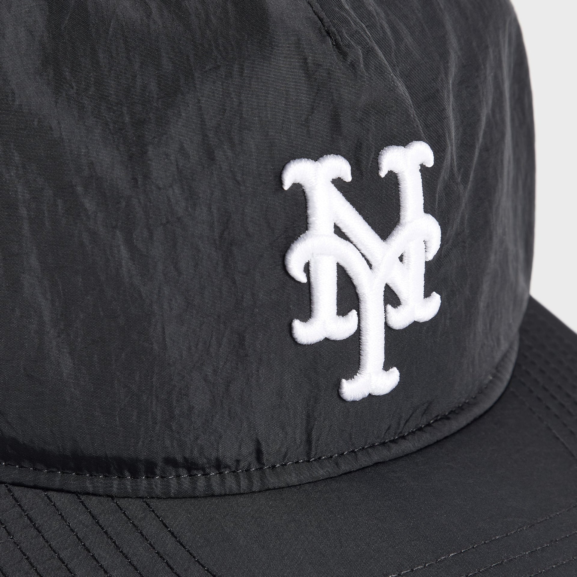 Close-up of the white embroidered NY Mets logo on the Kith and '47 nylon SL Hitch snapback