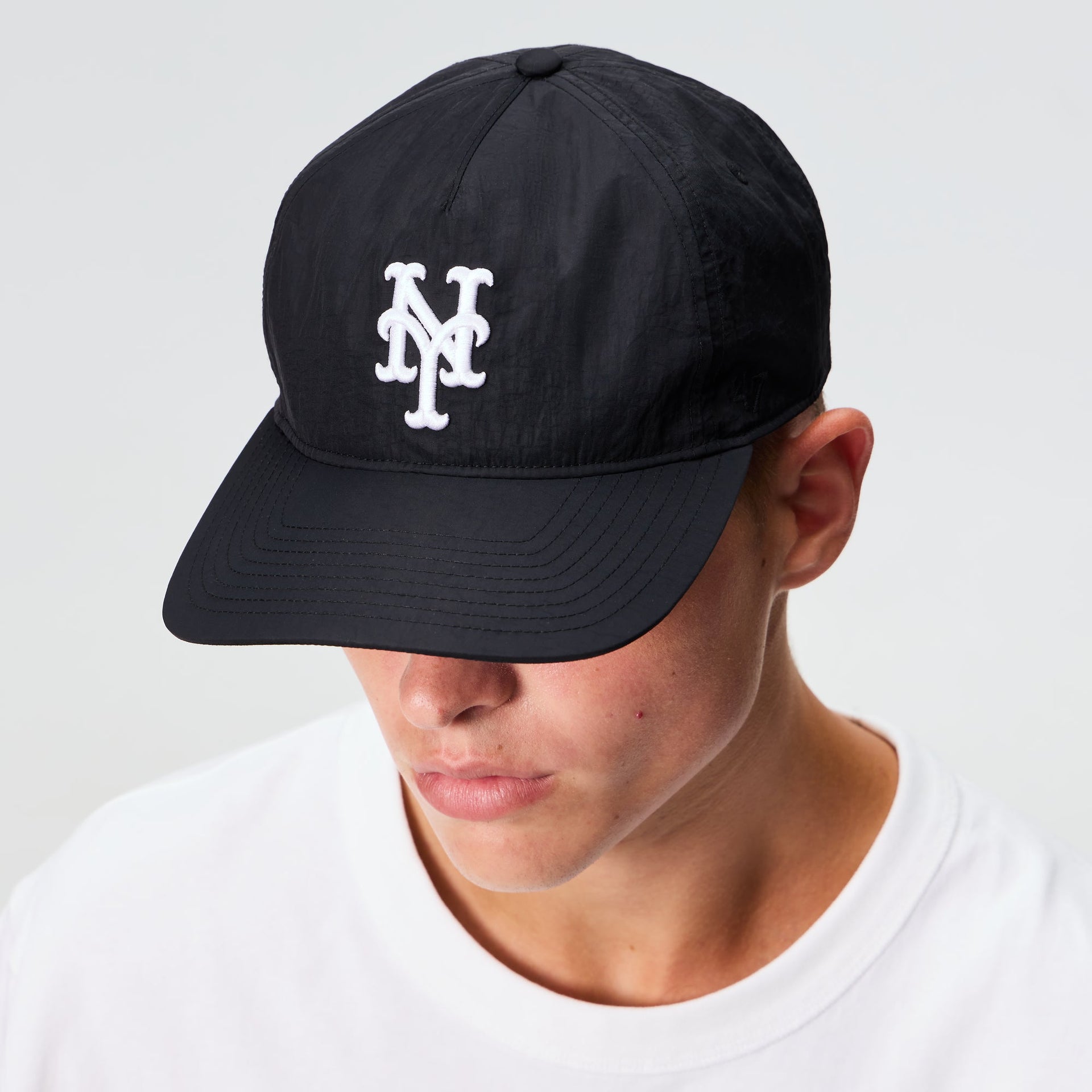 Man wearing the Kith and '47 New York Mets nylon SL Hitch snapback in black