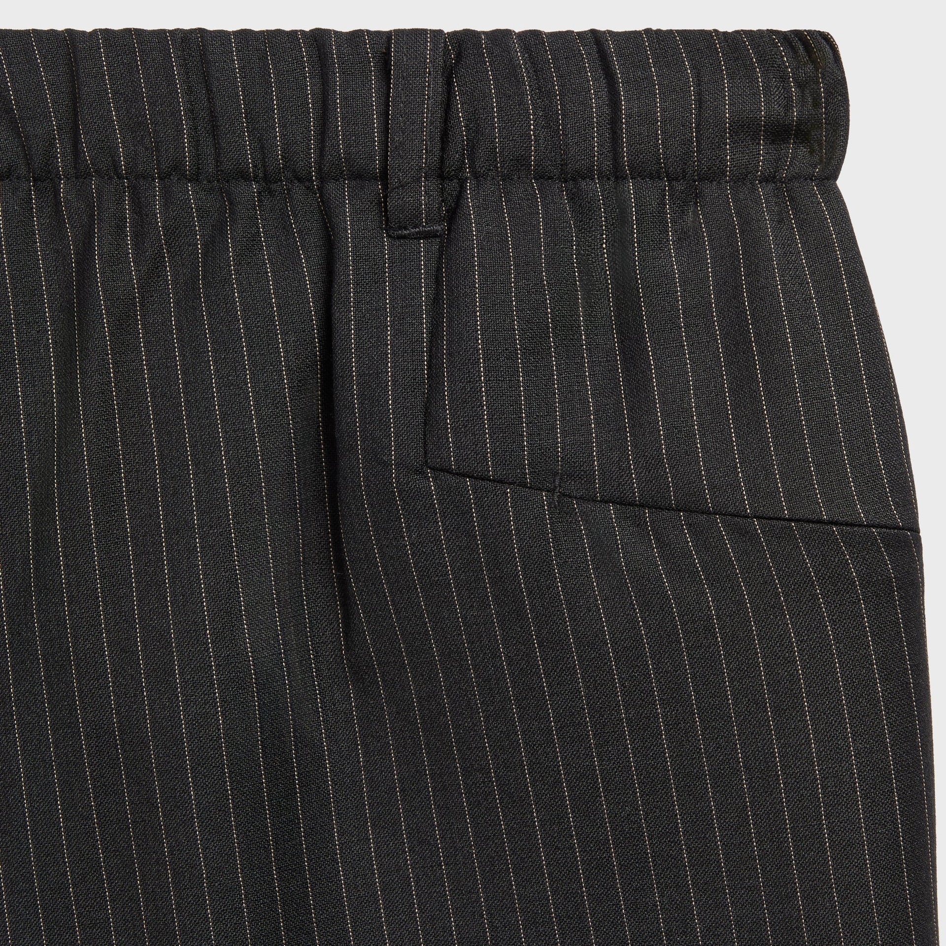 Close-up of the back welt pocket and tan pinstripe fabric on the Kith Idris pant