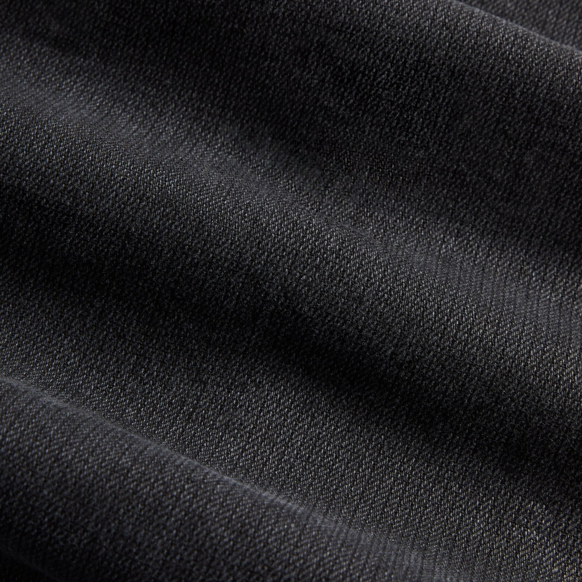 Close-up of the black herringbone denim texture on the Kith Zane cargo pant