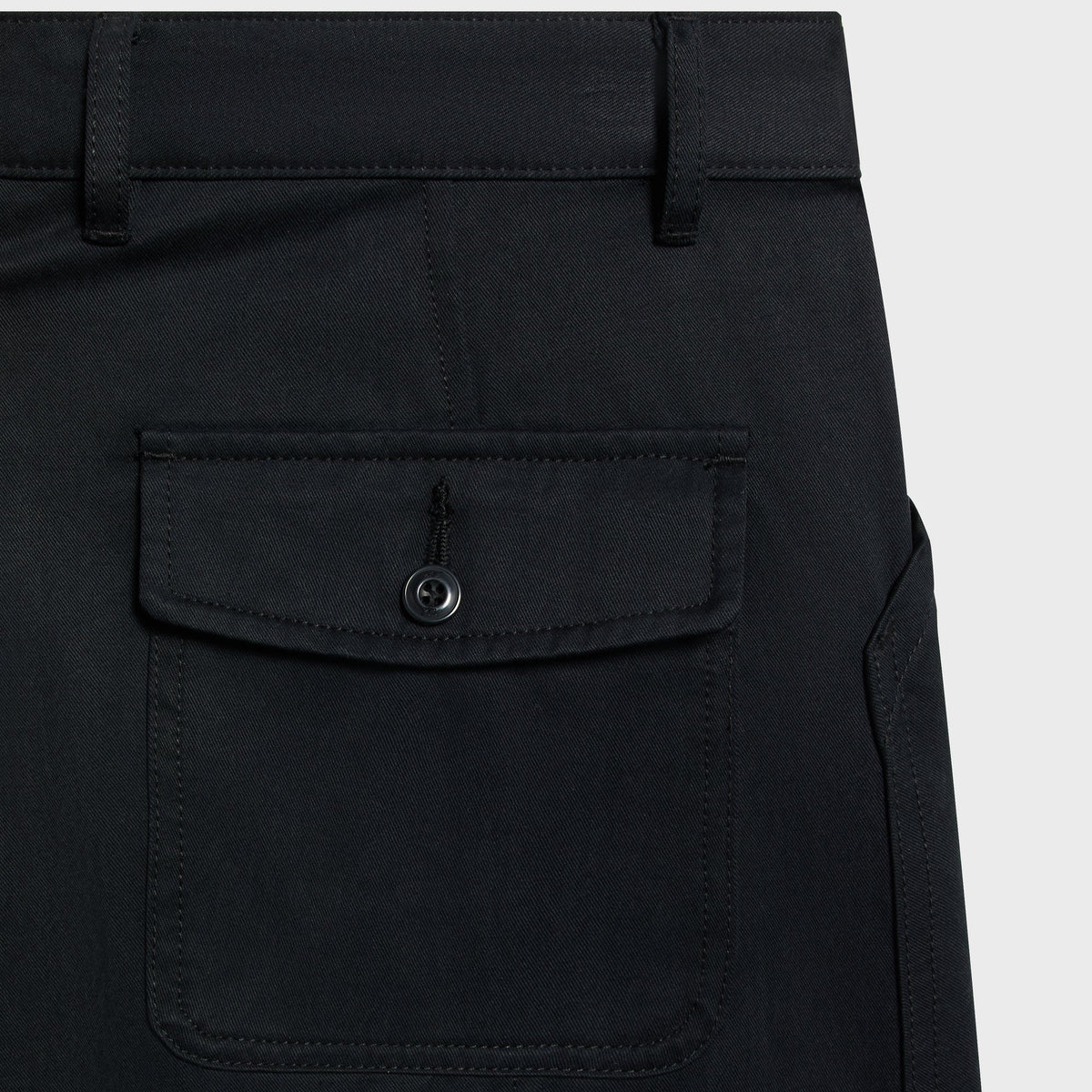 Close-up of the buttoned flap back pocket on the black Gus cargo pant
