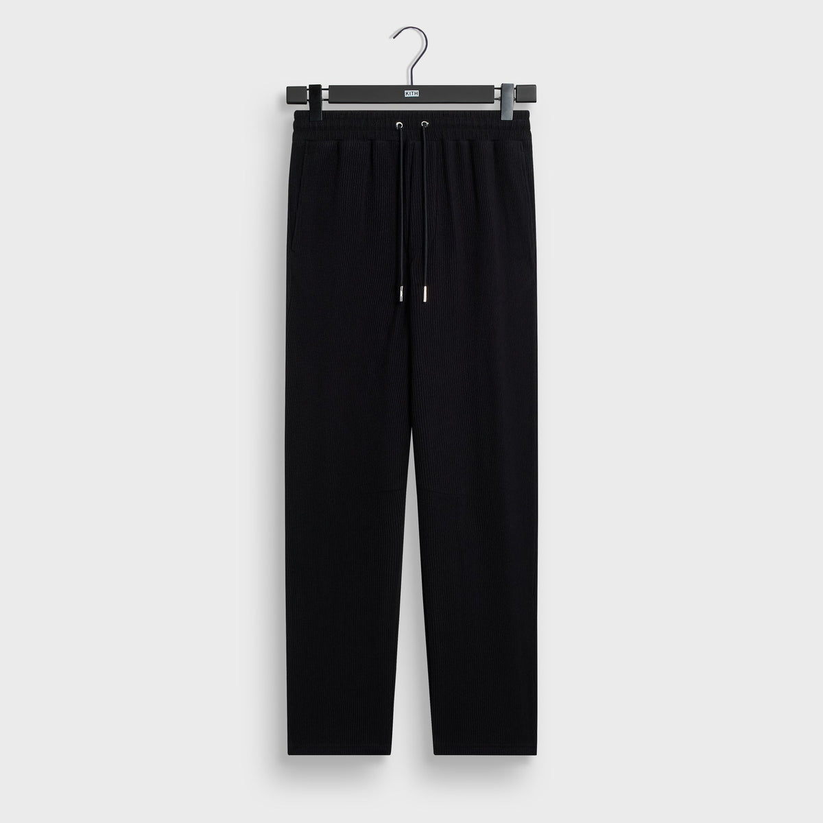 Kith Heavy Crepe Elmhurst Pant in black, front flat lay on hanger with elastic waist, drawcord and side pockets