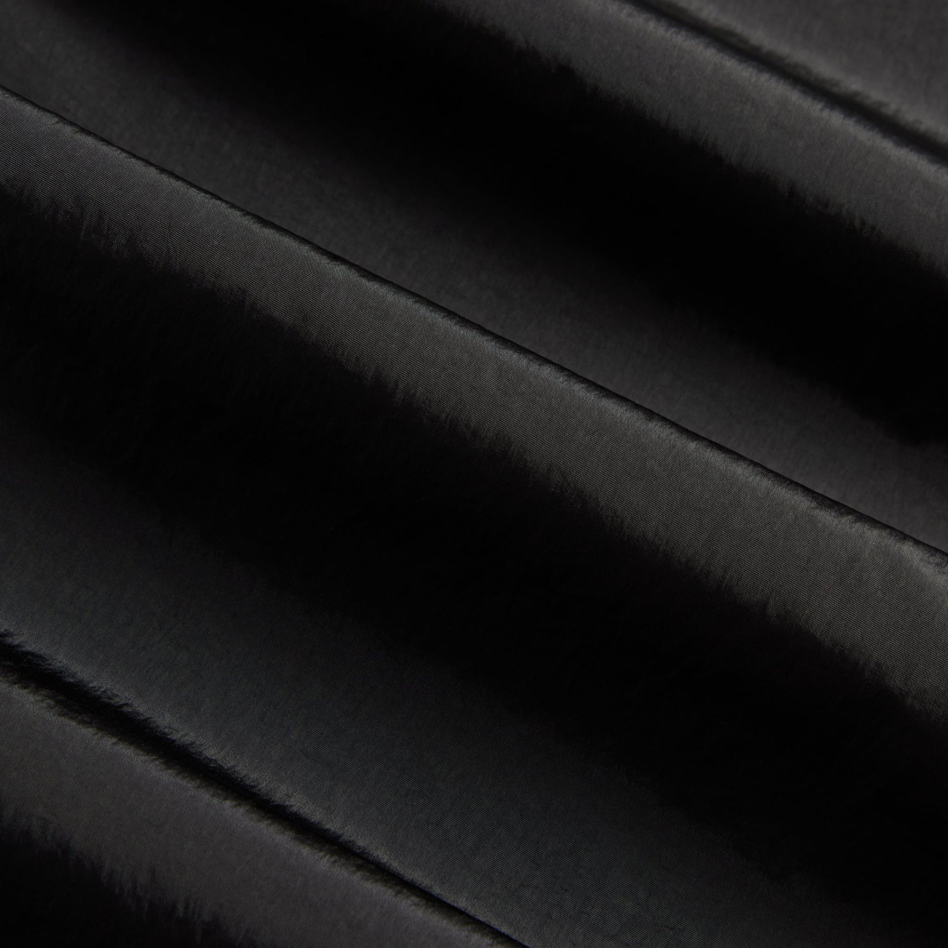 Close-up of the black nylon fabric texture on the Kith Seamed Nylon Bolt pant