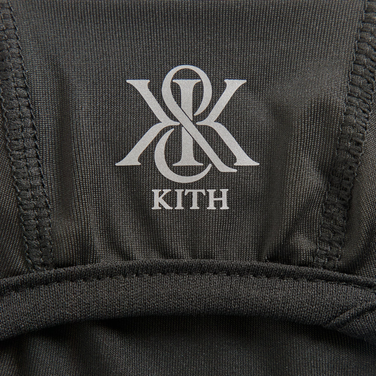Close-up of the reflective K and K KITH logo print near the face opening of the Poly Balaclava