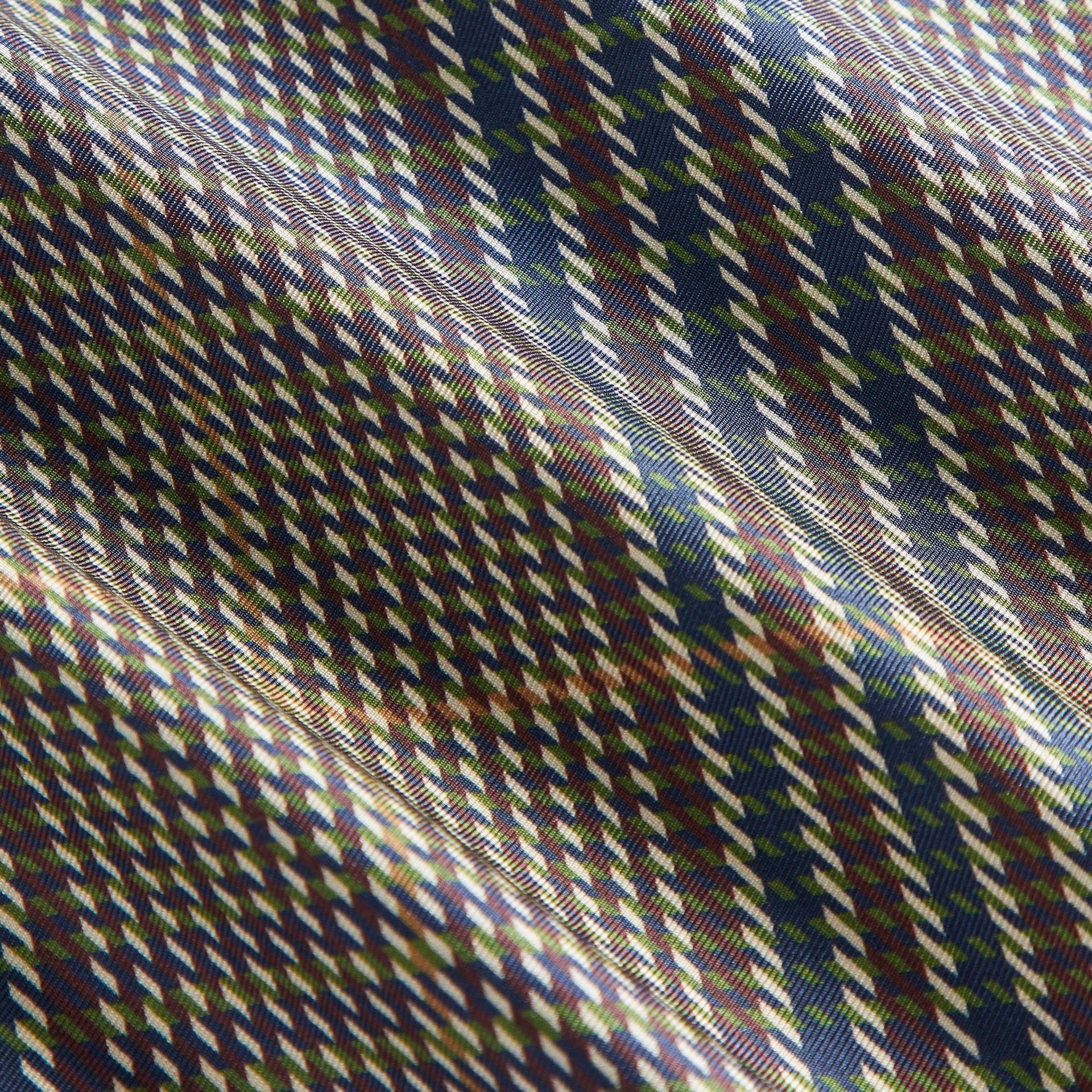Kith Printed Silk Scarf in Kindling, macro detail of the silk houndstooth weave in green, navy and burgundy
