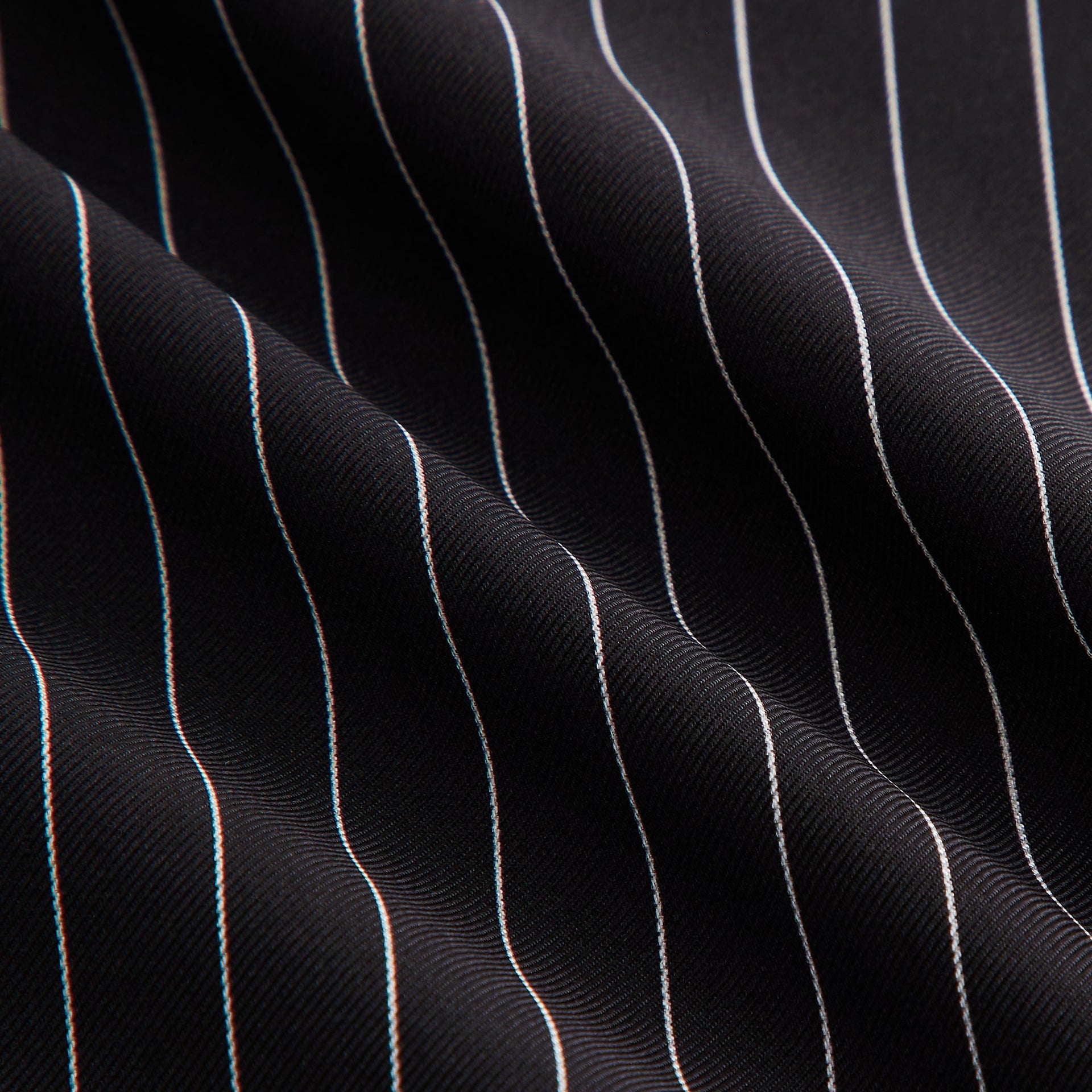 Close-up of the Kith Printed Silk Scarf in black pinstripe, showing the draped silk texture and fine pinstripe pattern.